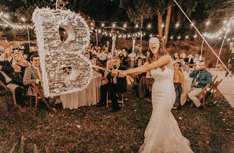 La mariée tapent dans une piñata, ajoutant une touche originale et festive au mariage.