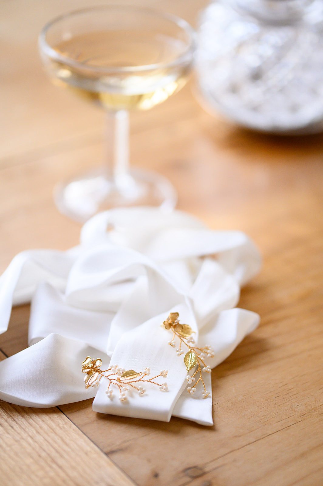 boucles d'oreilles pendantes en forme de fleur en perles rocaille sur un ruban blanc avec une coupe de champagne