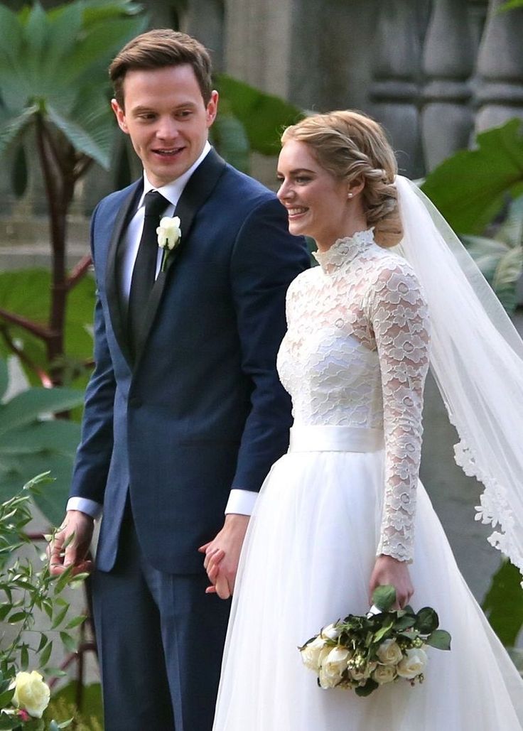 Margot Robbie rayonnante lors de son mariage, arborant un chignon élégant et romantique, orné de fleurs délicates. Cette coiffure met en avant son style sophistiqué et intemporel, offrant une inspiration parfaite pour les mariées en quête d'un look nuptial chic et glamour pour leur grand jour.