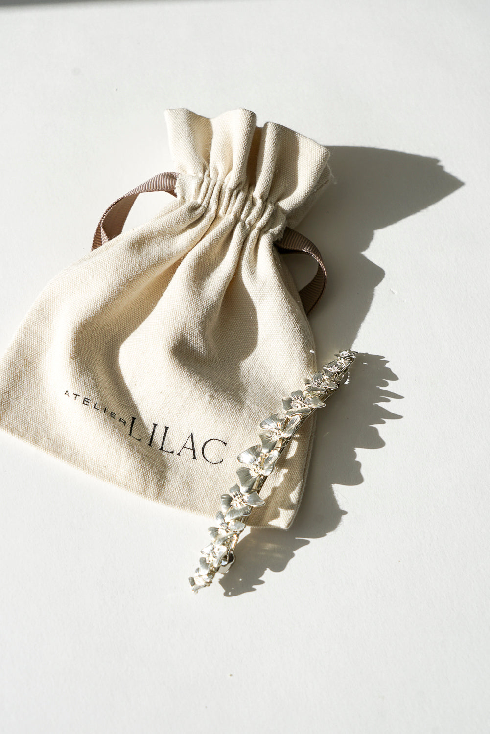 barrette cheveux argentée avec des fleurs avec son emballage en cotton
