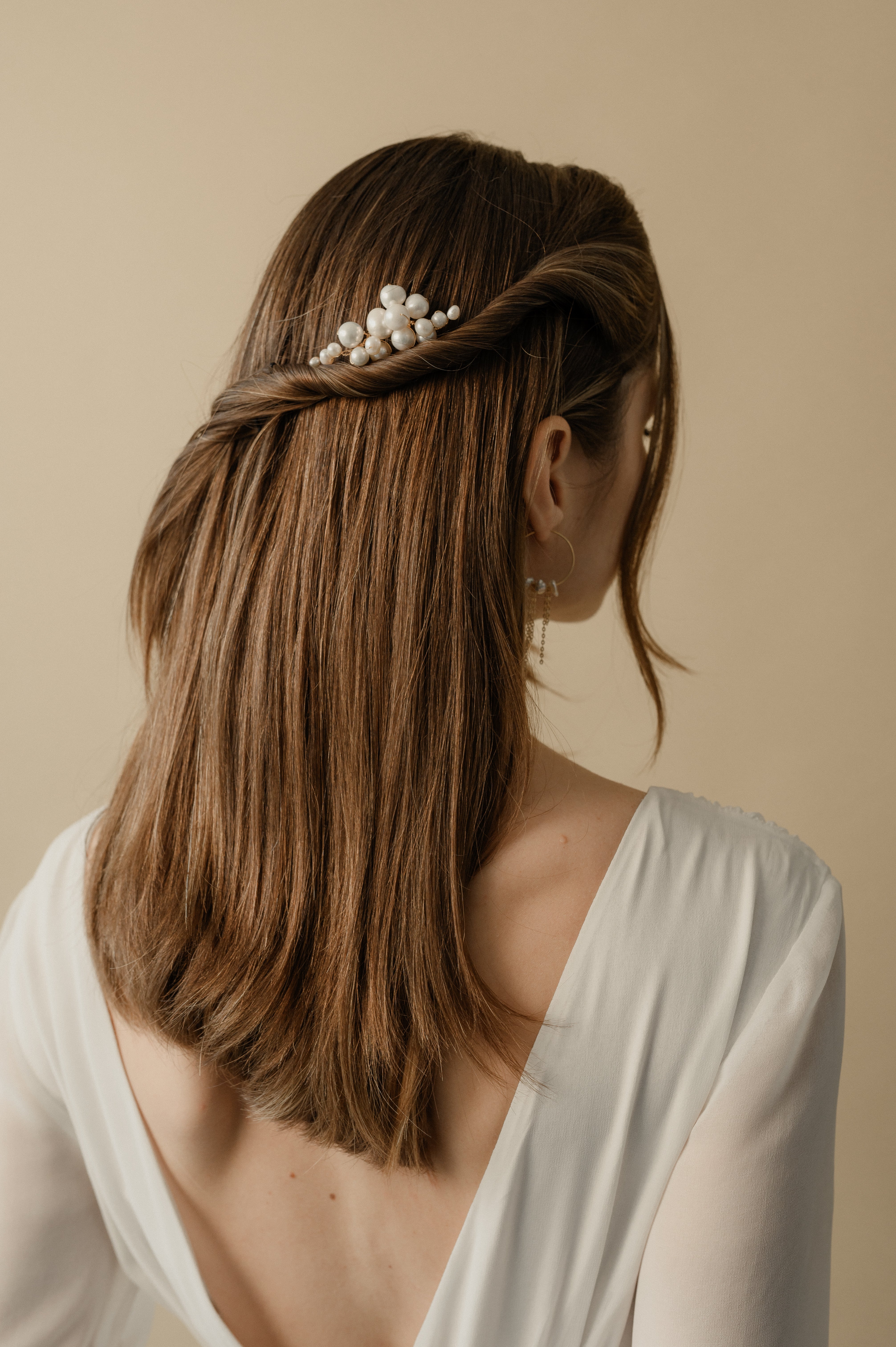 femme coiffée avec une demi queue de cheval et un peigne fait avec des perles naturelles