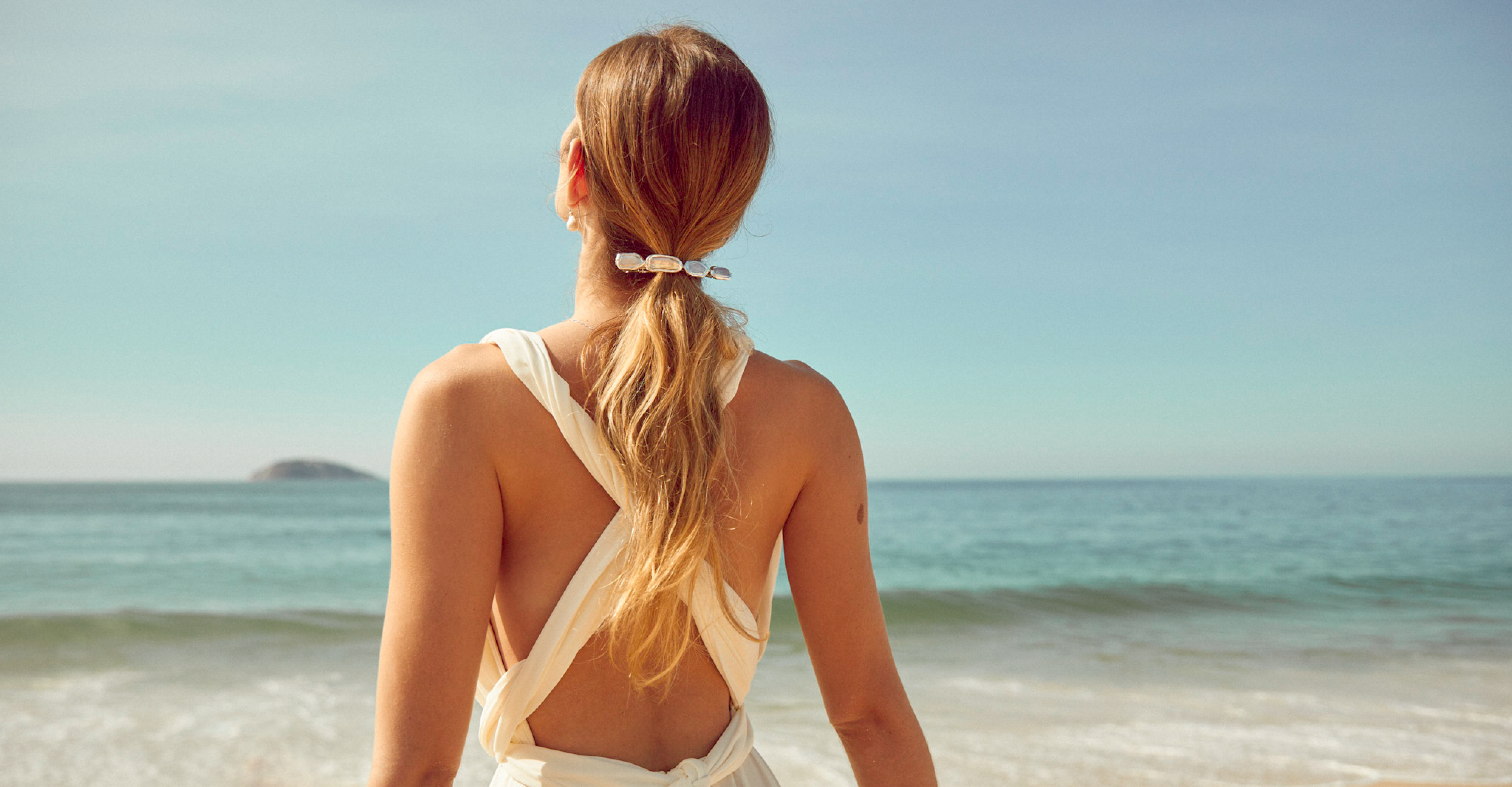 Plage avec une mariée de dos avec barrette en perles rectangulaires