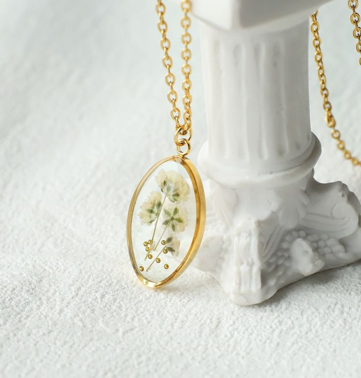 collier en or avec un pendentif en fleurs séchées pour garder un souvenir de son bouquet de mariage