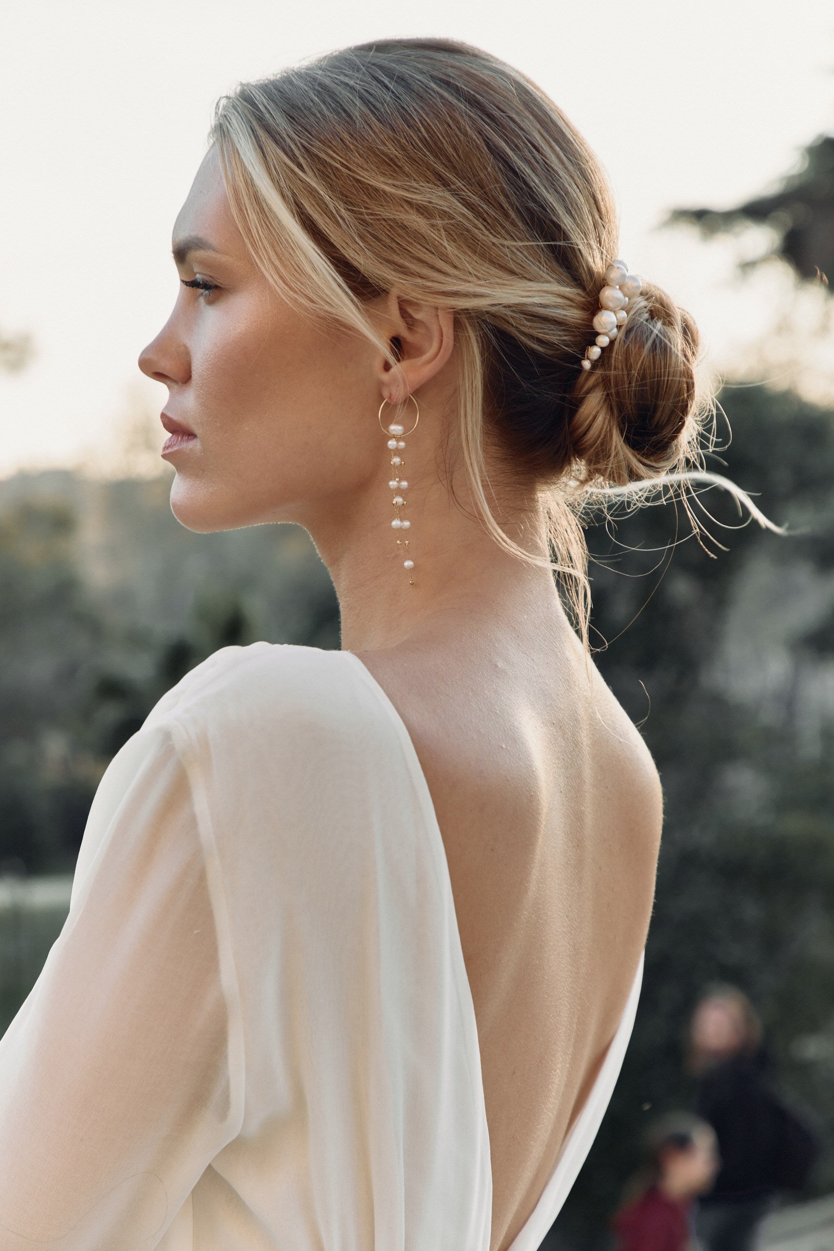 Mariée de profil portant un peigne et des boucles d'oreilles pendantes champêtre