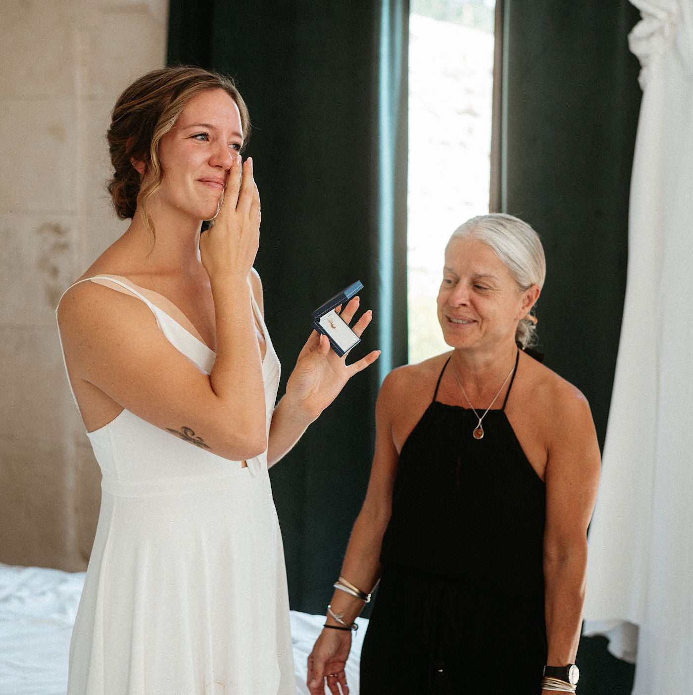 future mariée et sa maman avant le mariage entrain de vivre un moment d'émotions ensemble