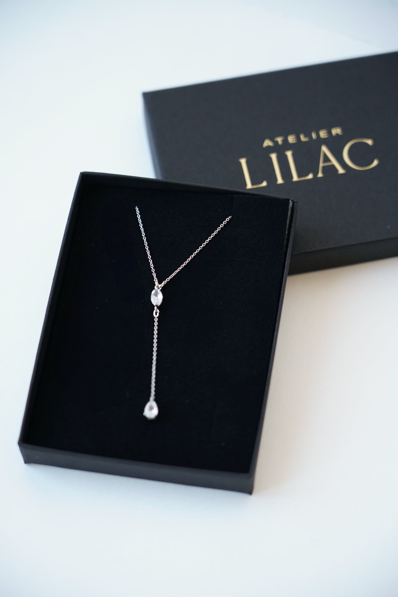 écrin à bijou rempli d'un collier de mariage en argent avec des cristaux lbanc