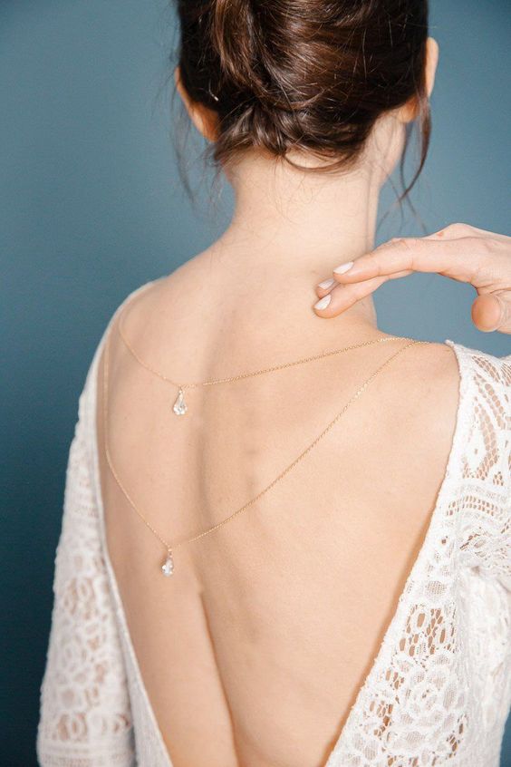 Femme montrant son dos et ses bijoux de mariage, avec son collier de dos à deux rangs