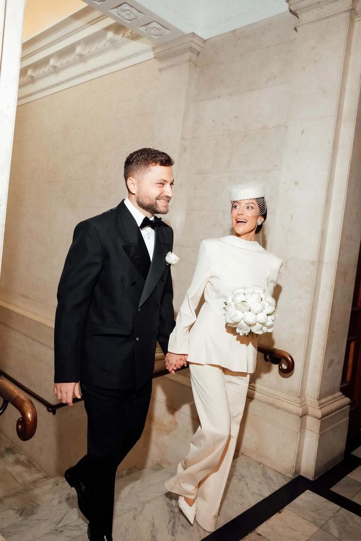 Mariées qui marchent vers la mairie , mariée avec pantalon, chapeau et voile