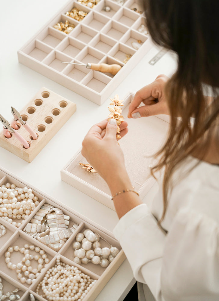 femme qui fabrique des bijoux de mariee avec des perles et des fleurs