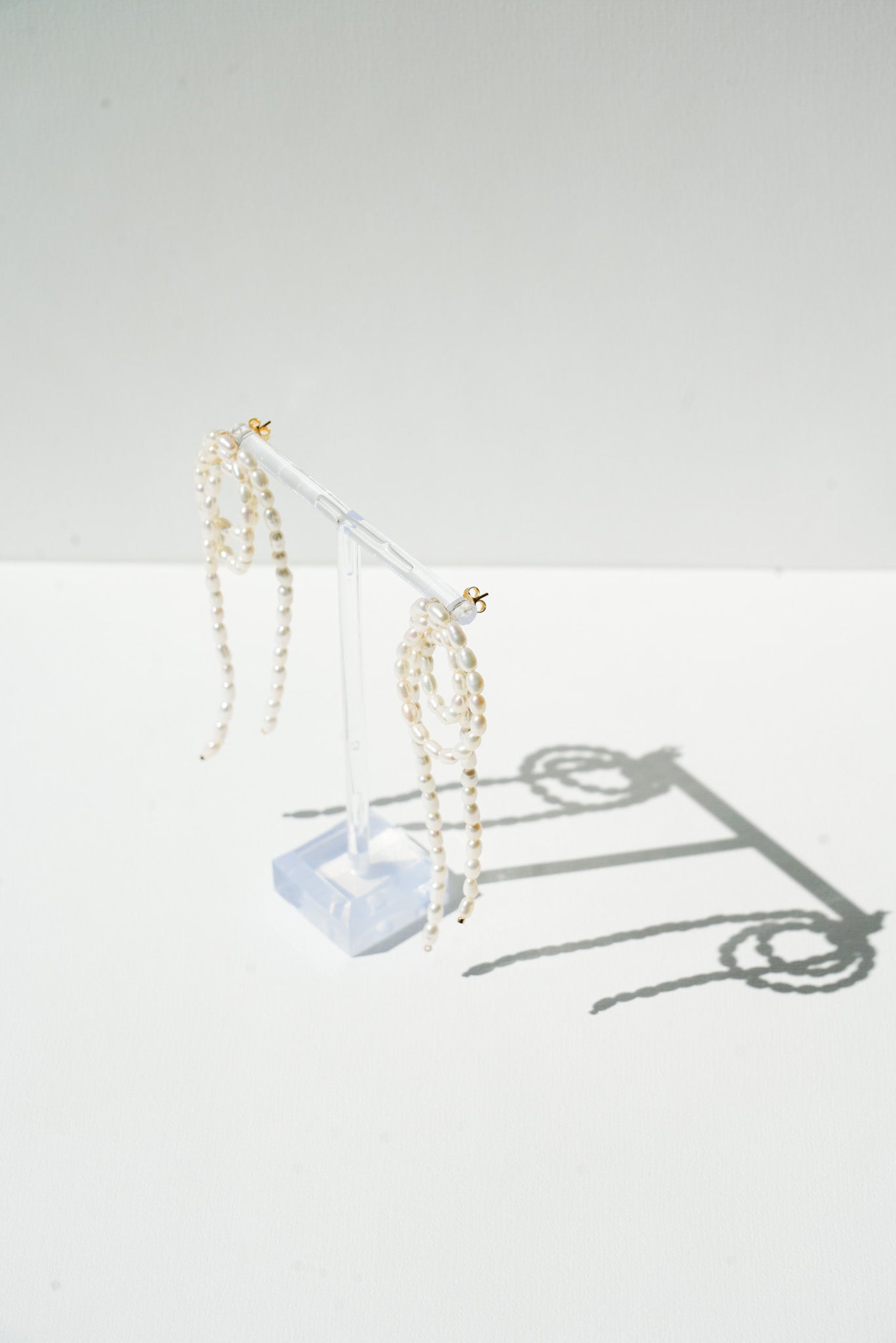 boucles d'oreilles moderne en ferme de cercles superposé de perles naturelles avec une ombre d'elle même