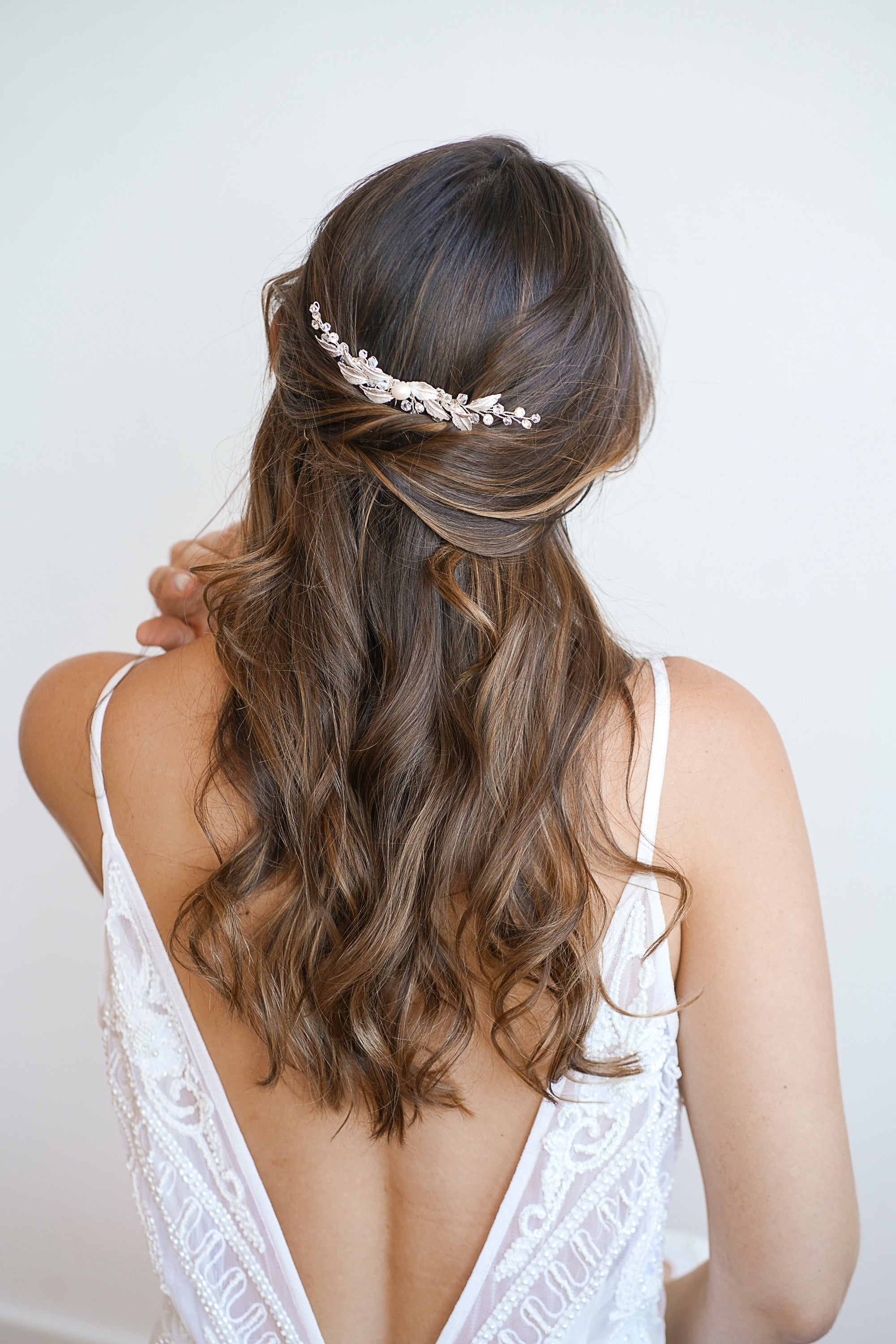 Mariée portant un peigne de mariage bohème fait de feuilles en argent, de perles et de cristaux