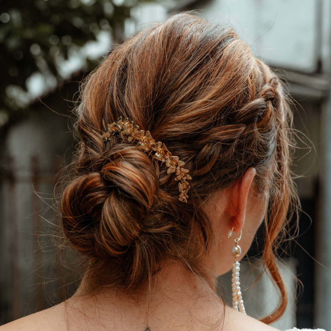 Beau chignon bas de mariée délicatement orné d'une pince élégante, parfaite pour une coiffure nuptiale raffinée et sophistiquée lors du grand jour.