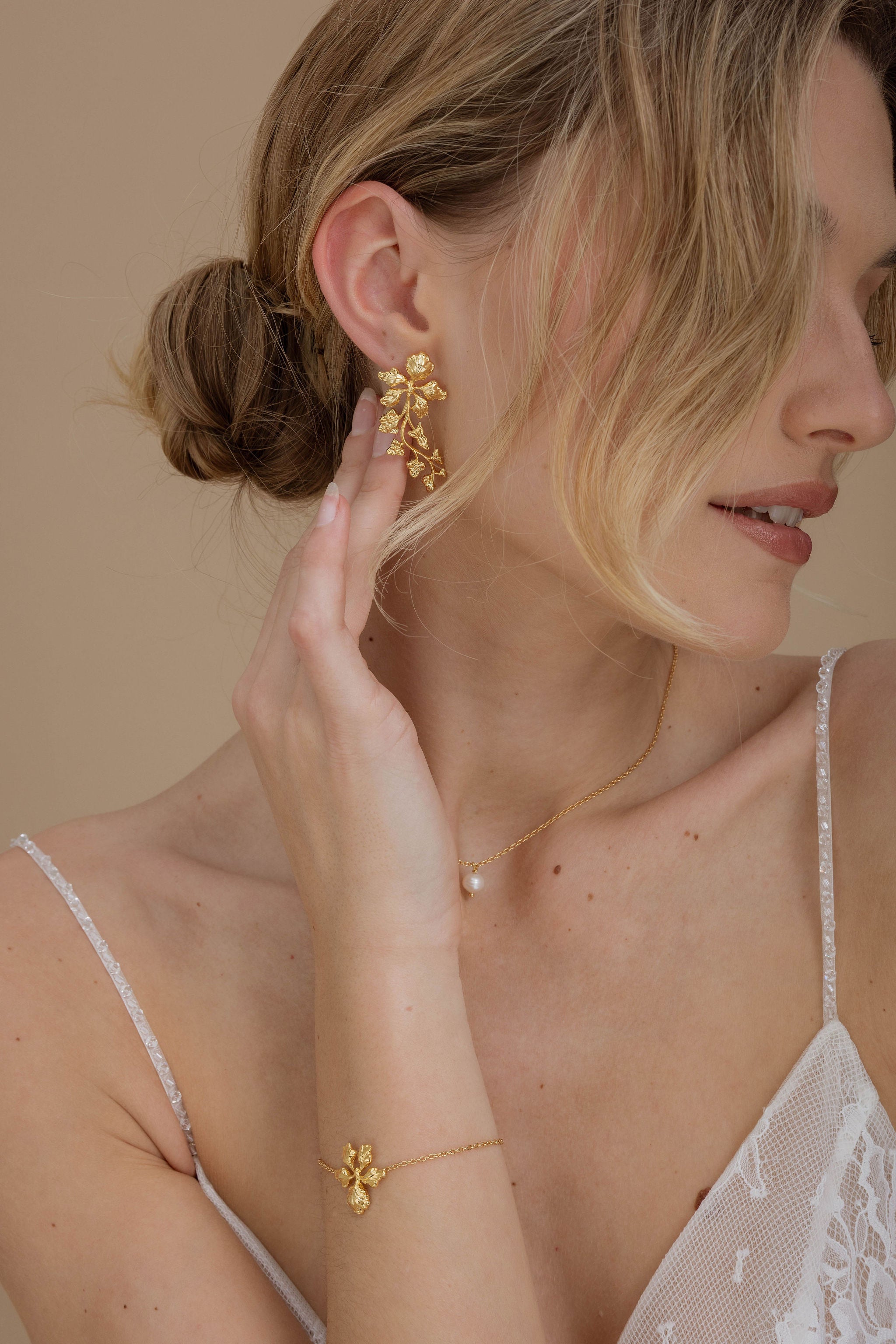 Boucles d'oreilles florales délicates, qui complètent magnifiquement un chignon bas et une mèche, ajoutant une touche de romance et de sophistication.