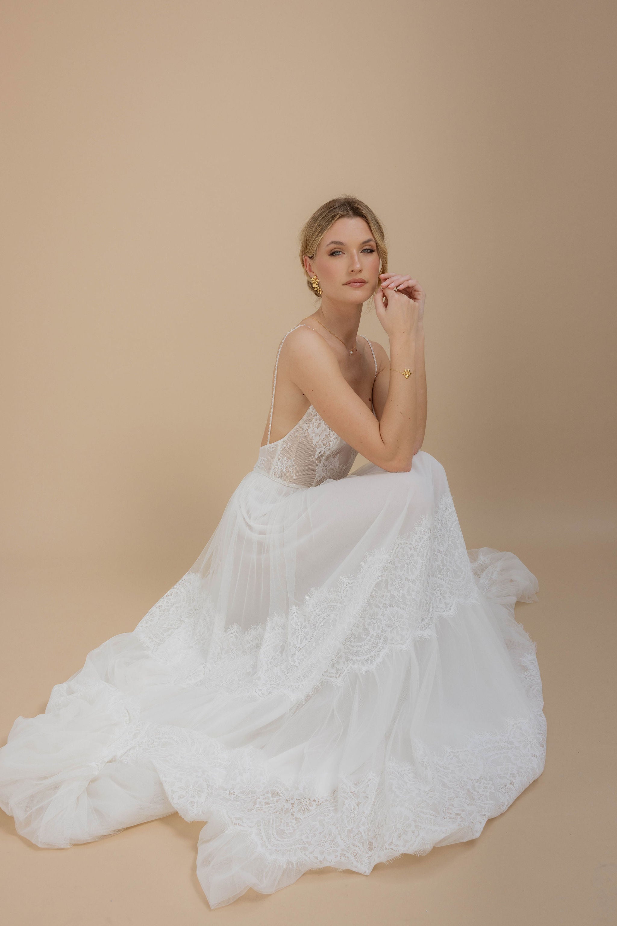 Boucles d'oreilles longues et bracelet floral, parfaits pour une mariée en jolie robe, avec un chignon élégant, apportant une touche délicate à son look.