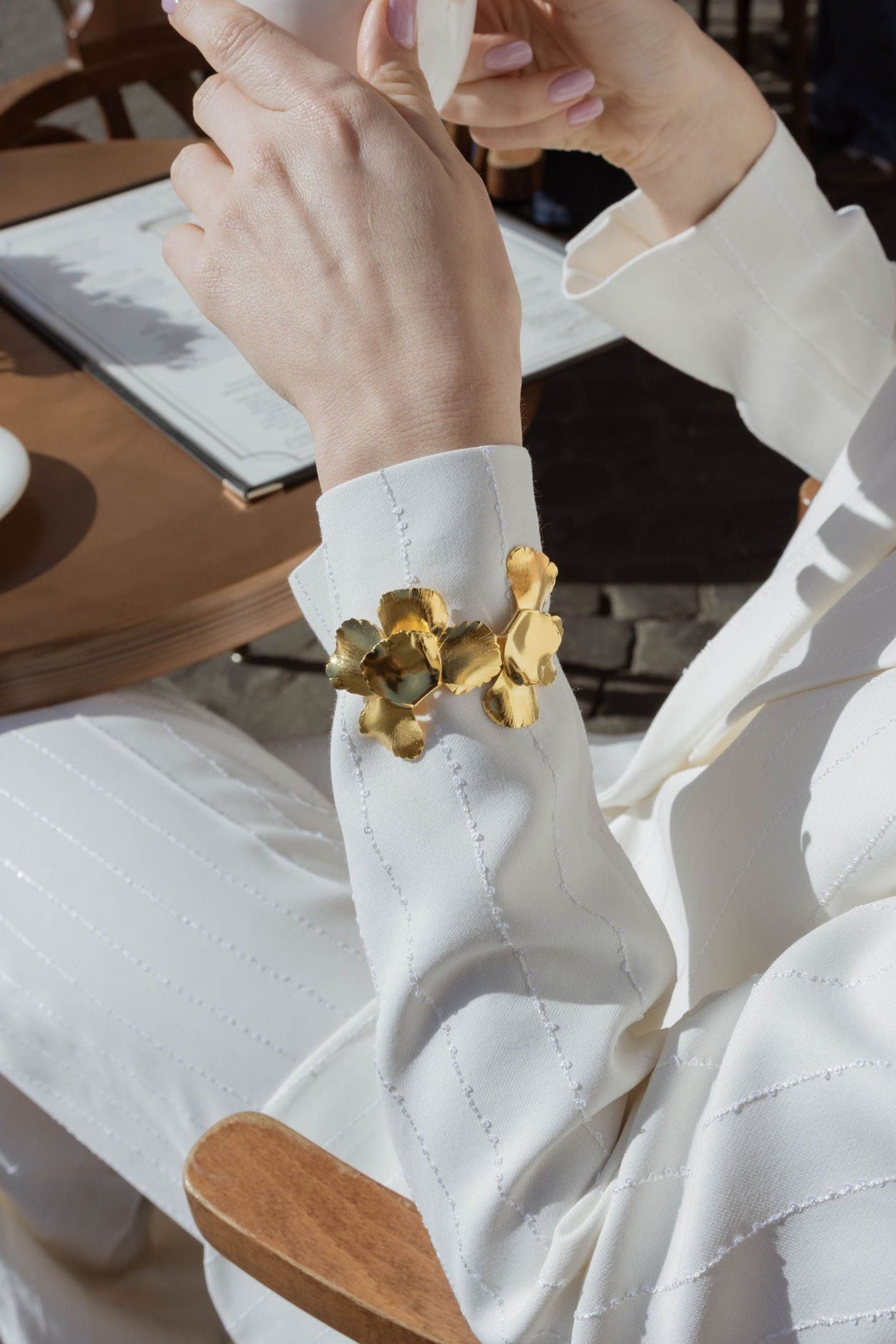Mariée à l'extérieur montrant son bracelet floral imposant pour les grandes occasions