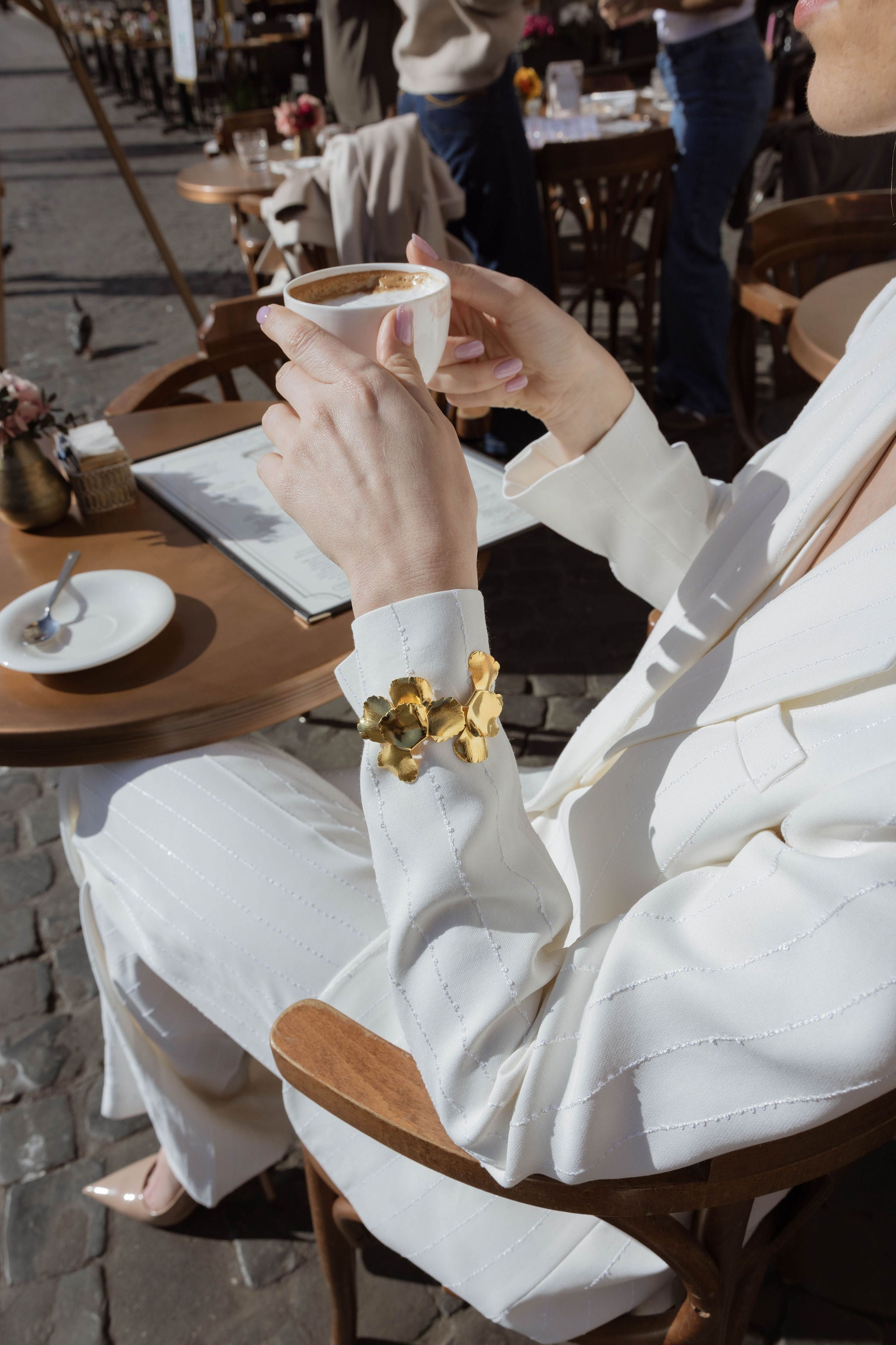 Focus sur la manche d'une femme portant un costume de mariage montrant son accessoire de cérémonie floral