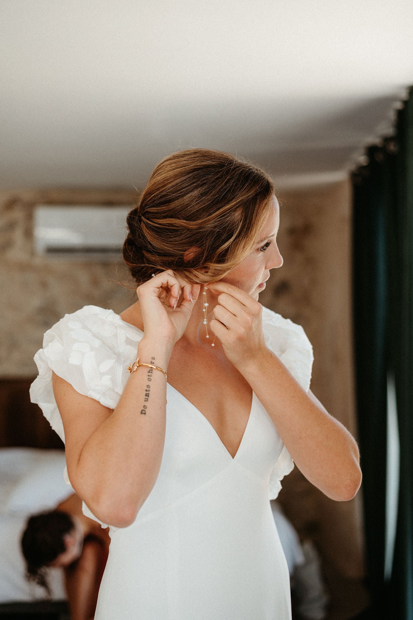 mariée entrain mettre sa boucle d'oreilles pour le jour de son mariage