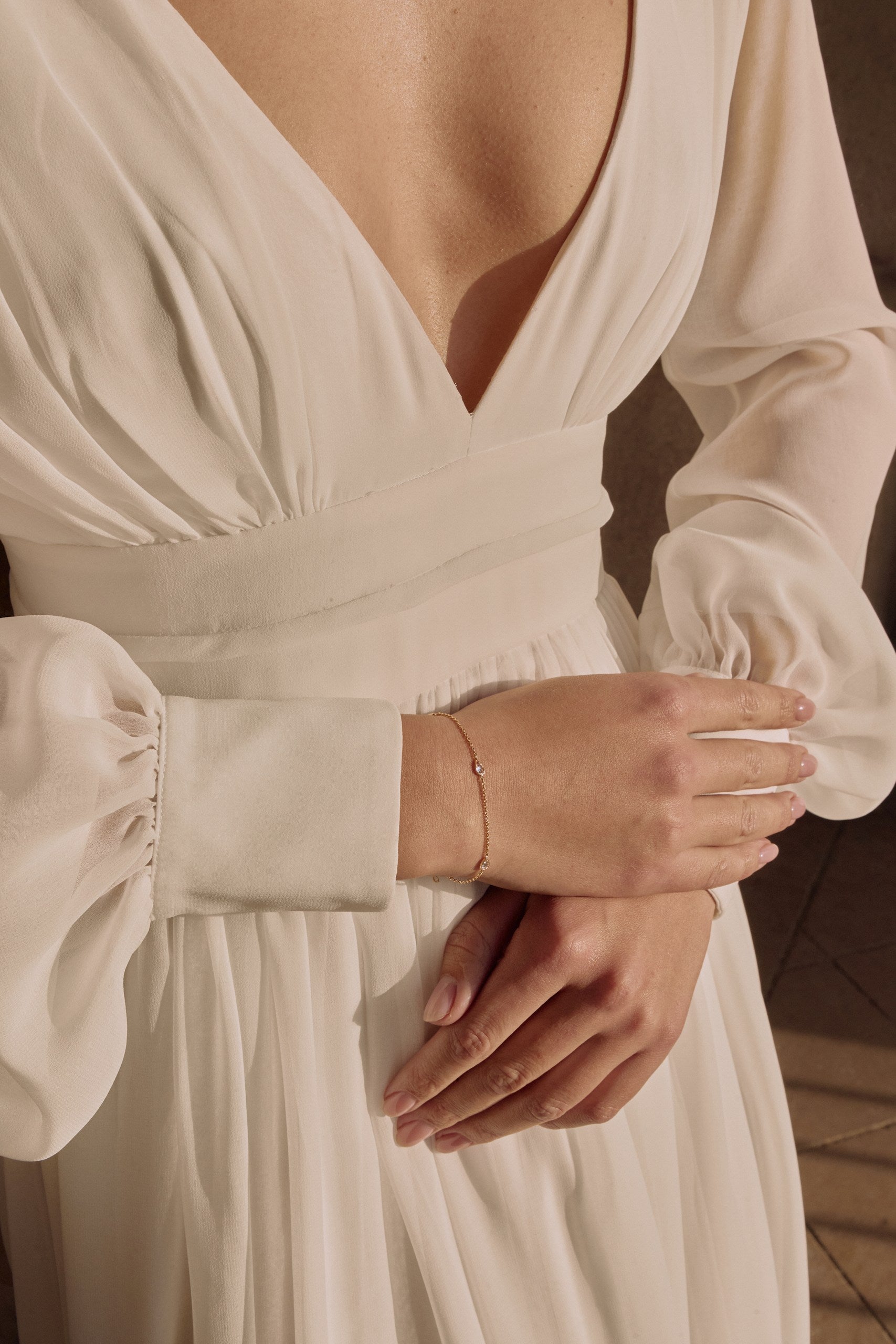 Future mariée croisant les mains avec un bracelet à pierre précieuse au poignet