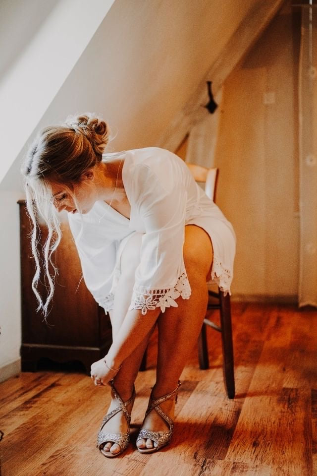 Jeune mariée qui se prépare en mettant ses chaussures dans son kimono de mariage