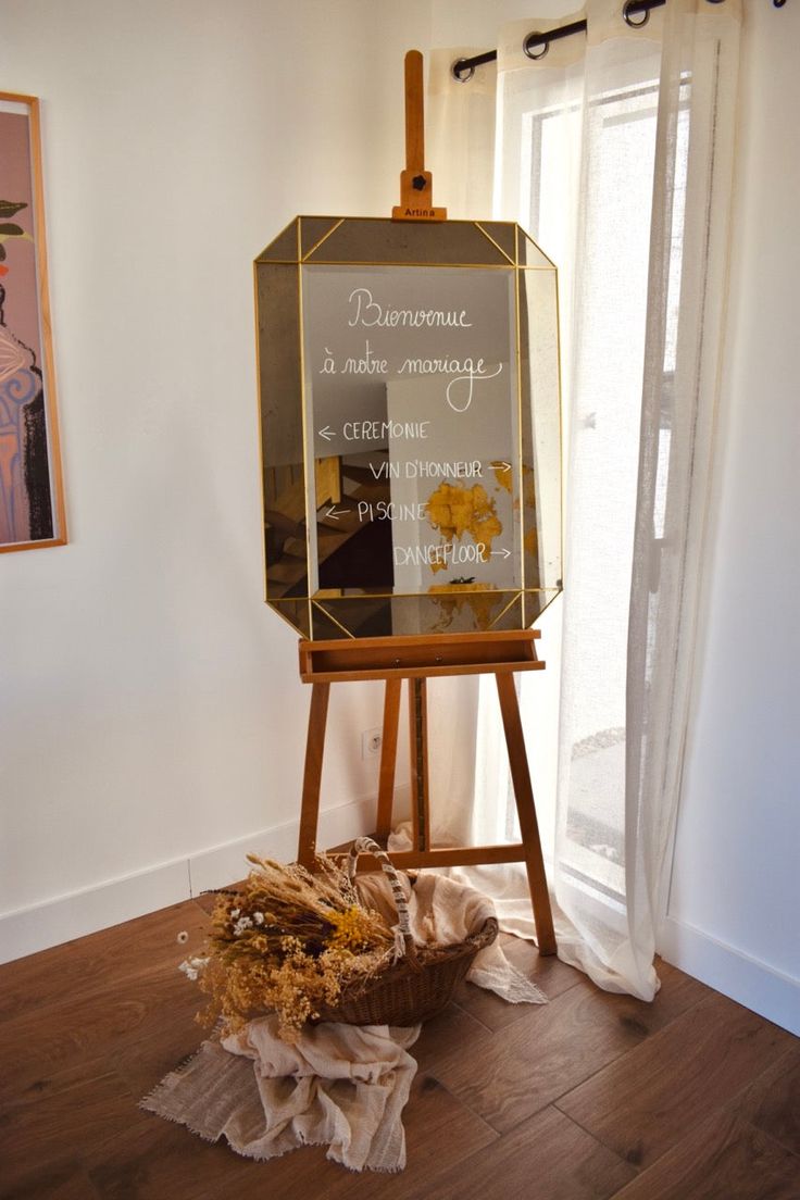 chevalet avec un miroir pour la présentation du mariage avec des fleurs séchées jaune sur le bas
