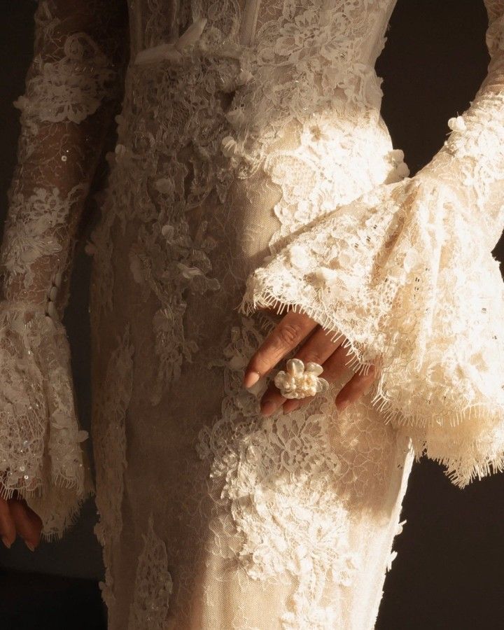 Detail des manches de robe de mariee en dentelle d'une mariee hivernale