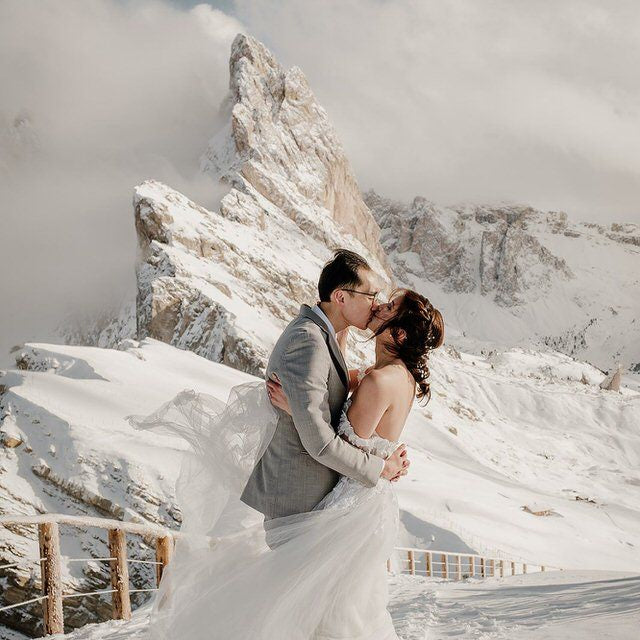 Couple en hiver qui se marient sous la neige et qui s'embrassent