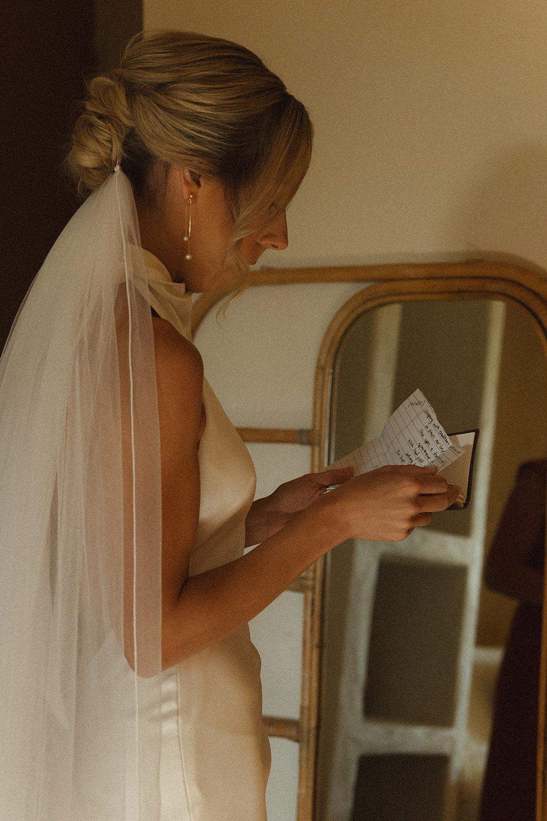 Mariée de dos avec un chignon bas délicat et bien serré, mettant en avant une coiffure élégante et raffinée, parfaite pour un mariage classique et sophistiqué.