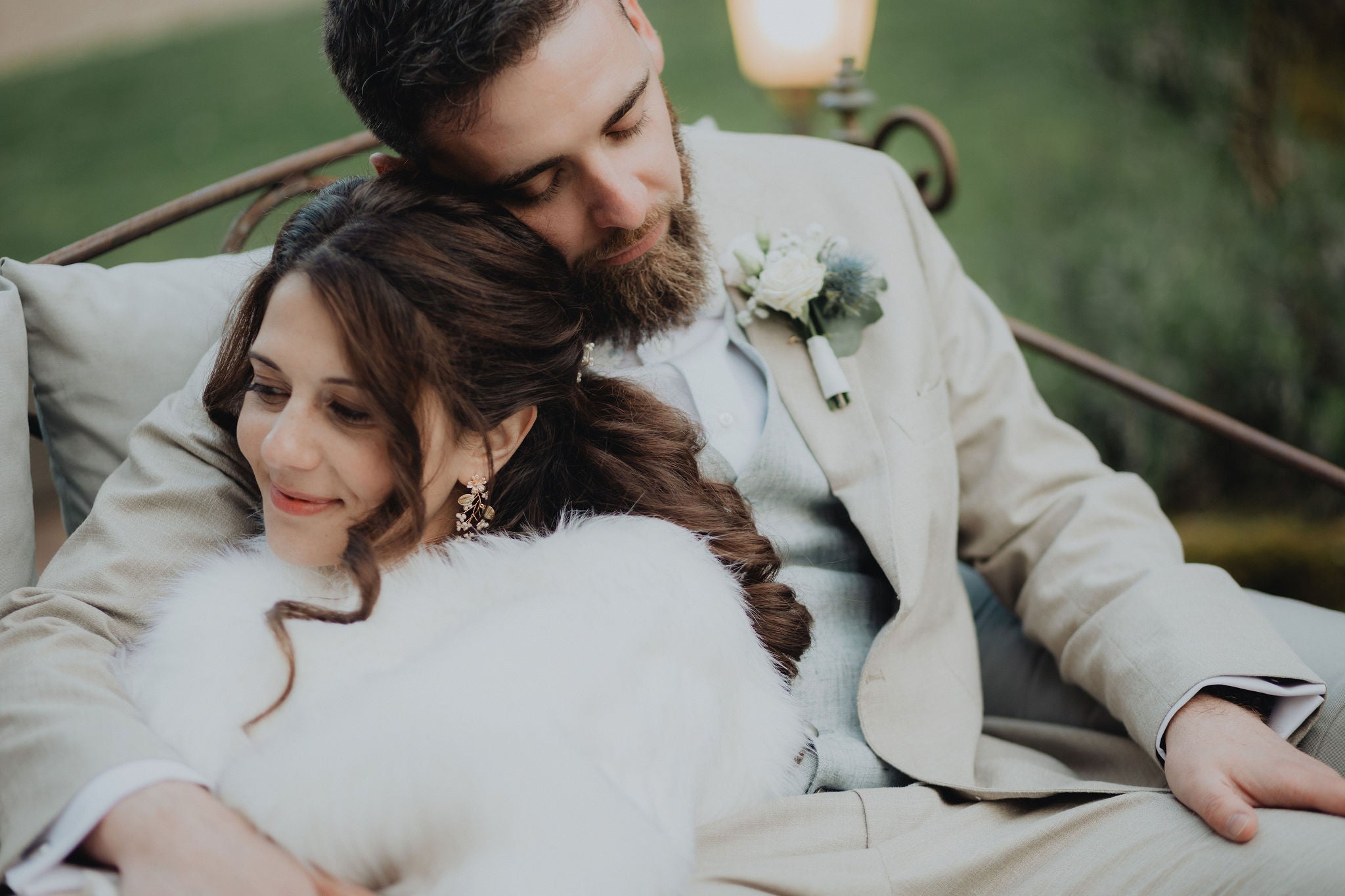 couple le jour de leur mariage enlacé sur un canapé en exterieur