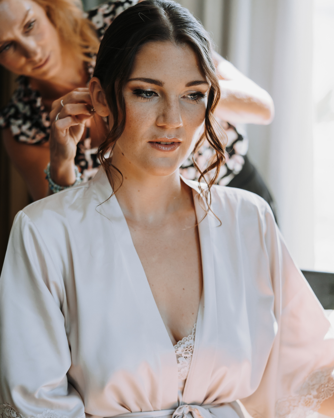 Une femme essayant son maquillage et sa coiffure de mariage, se préparant quelques jours avant le grand jour. Ses mains soignées, avec des ongles impeccables, complètent cette étape cruciale des soins avant mariage. Conseils beauté, bonnes habitudes, et une routine mariage bien définie sont au cœur de cette préparation pour un look parfait.