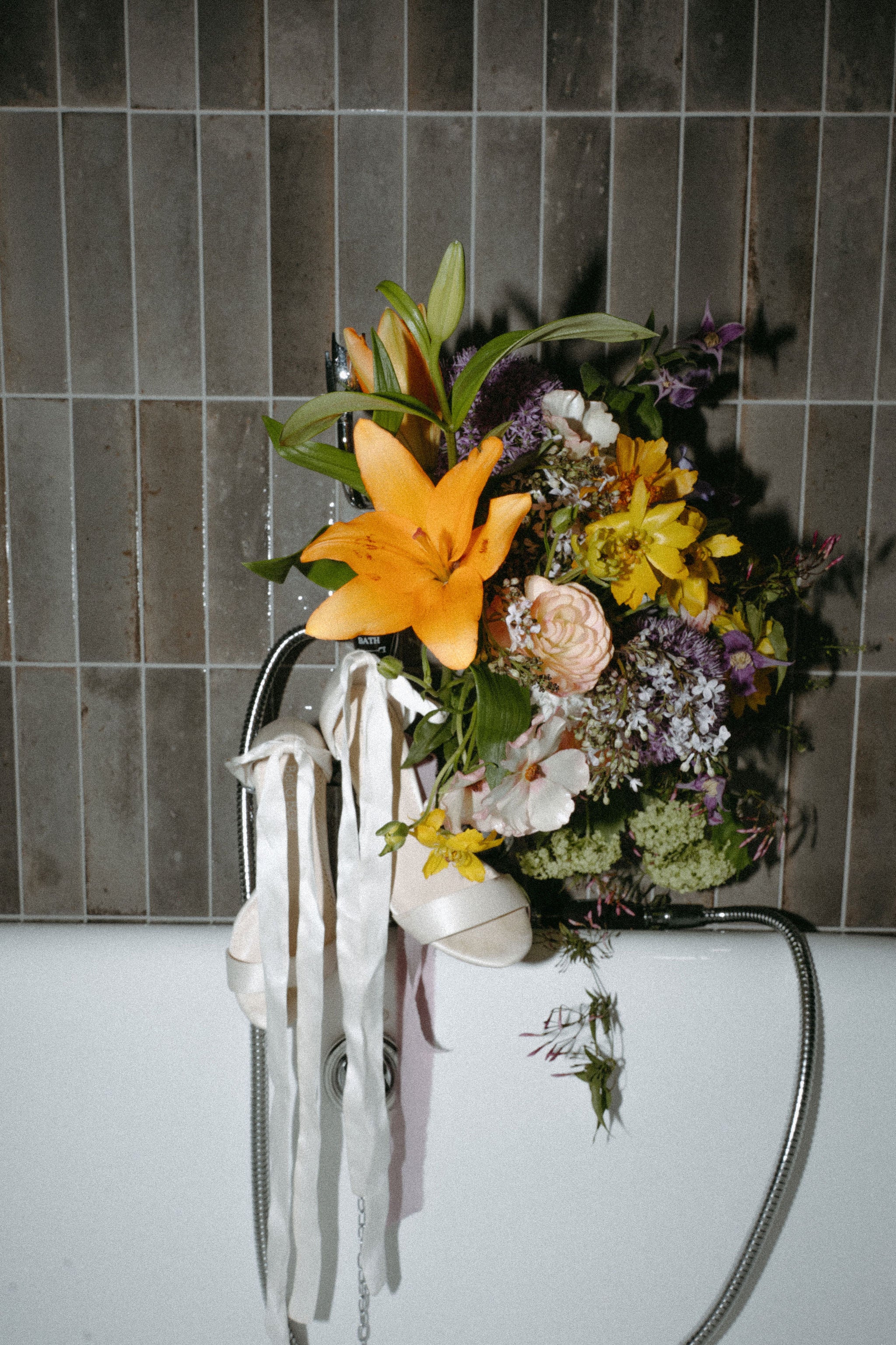 Photo esthétique éditoriale du bouquet de fleurs de la mariée dans une baignoire, bouquet mariage, mariage élégant, salle de bain mariage, photoshoot mariage, talons mariée, chaussures mariée, fleurs mariage
