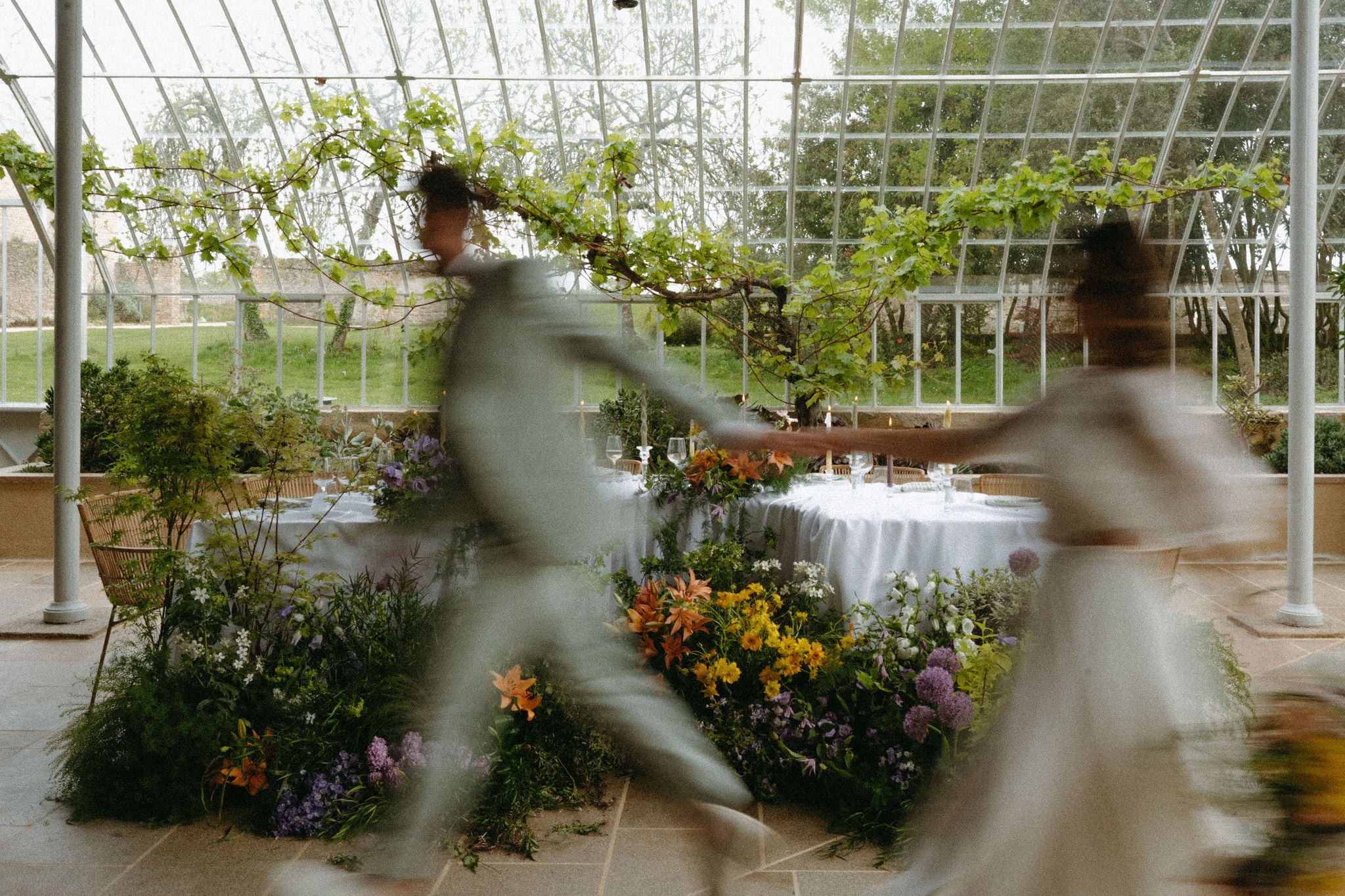 Photo horizontale floue d'un couple qui court en se tenant la main, photo romantique mariage couple marié, robe de mariée, costume mariage, fleurs mariage , réception château mariage, inspiration mariage élégant