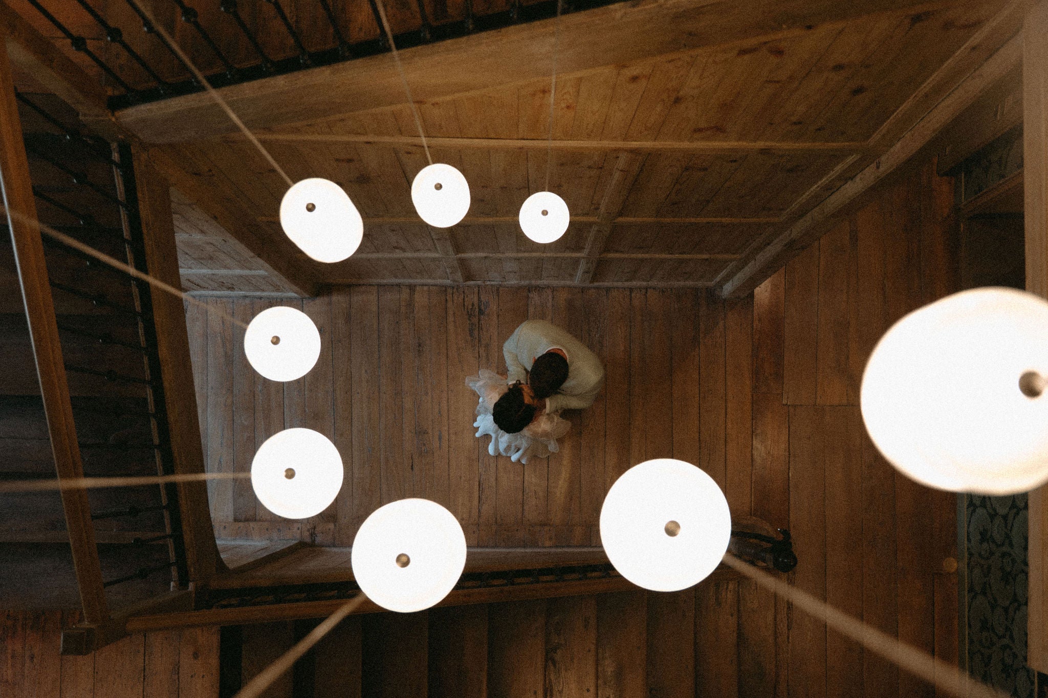 Couple marié s’embrassant sur un escalier de château, mariée en robe blanche, marié en costume