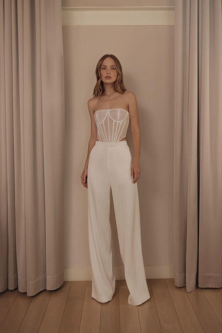 Mariée moderne qui porte un pantalon et un corse en tulle, elle a les cheveux courts