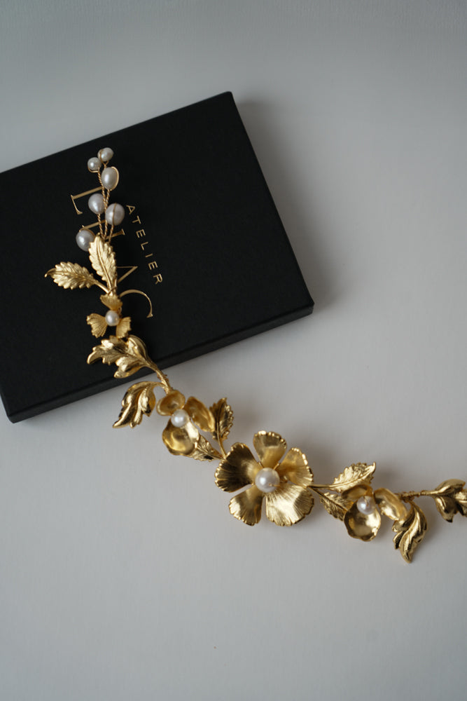 bijoux de mariage en or avec des fleurs et des perles naturelles posé sur une boite à bijoux noir