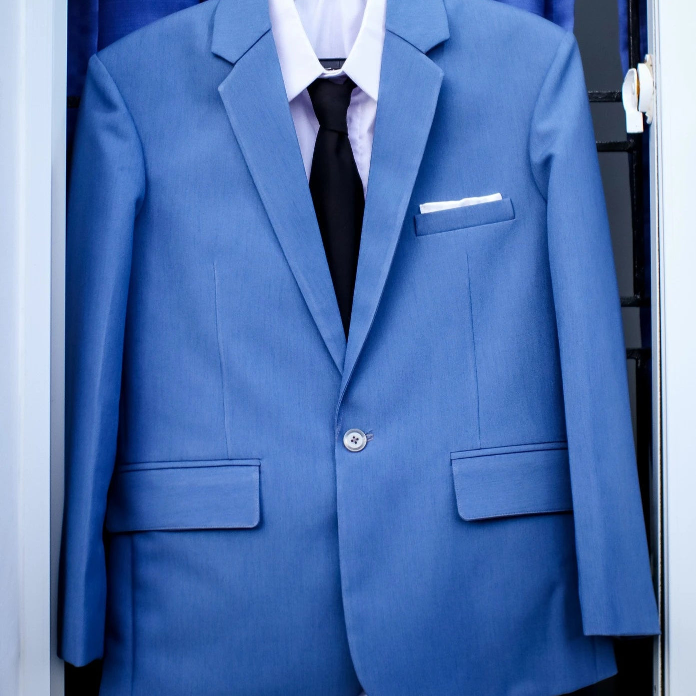 Costume de mariage pour homme sur un cintre à l'extérieur bleu marine avec la cravate