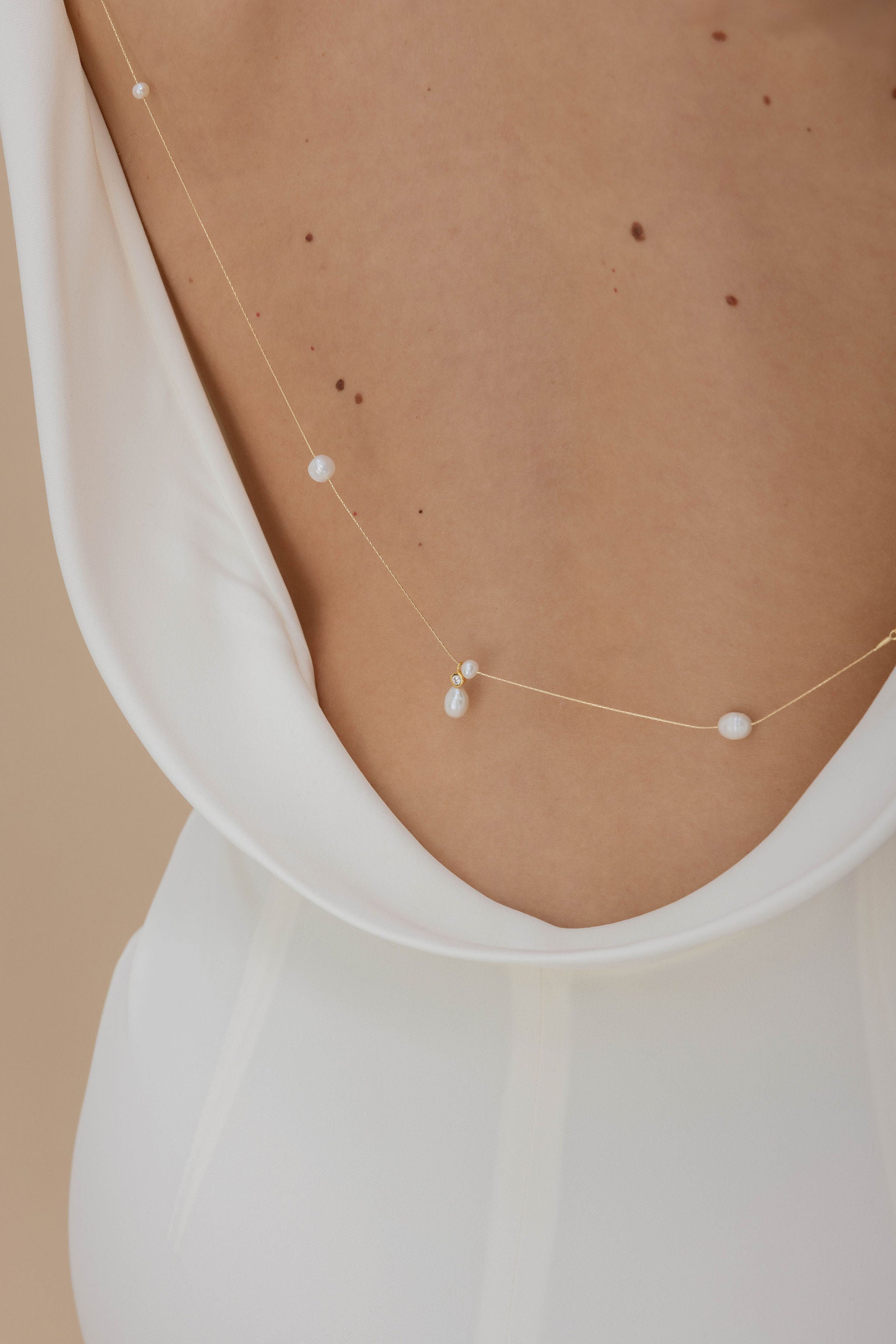 Détails d'un accessoire de décolleté de dos avec différentes formes perles naturelles pour les cérémonies