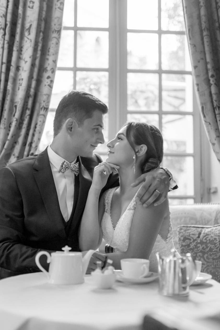 Deux mariés qui se regardent dans les yeux montrant leurs bijoux de cérémonie