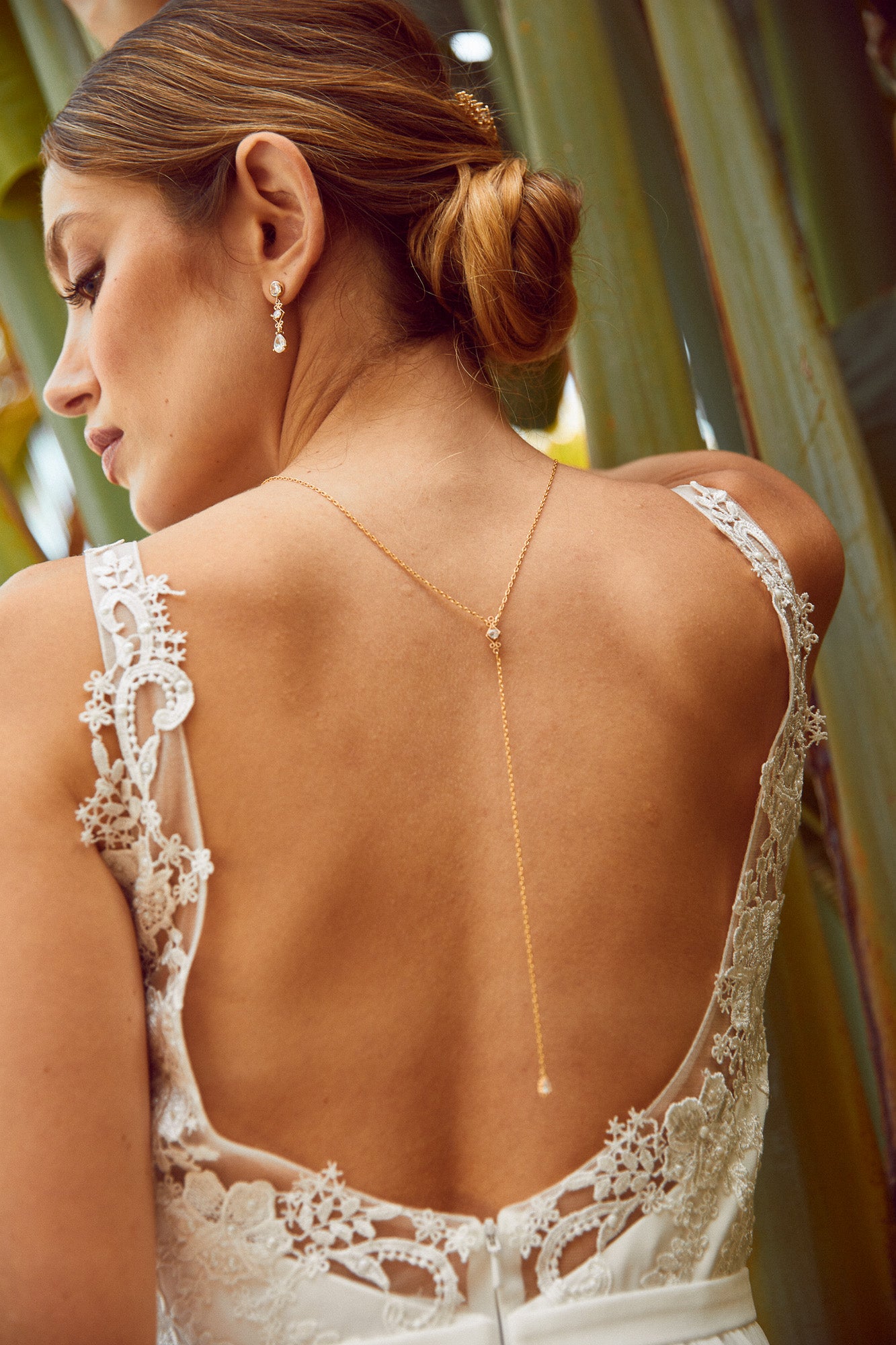 mariée bohème portant un collier de dos pour mariage dans son dos sur le lieu de réception