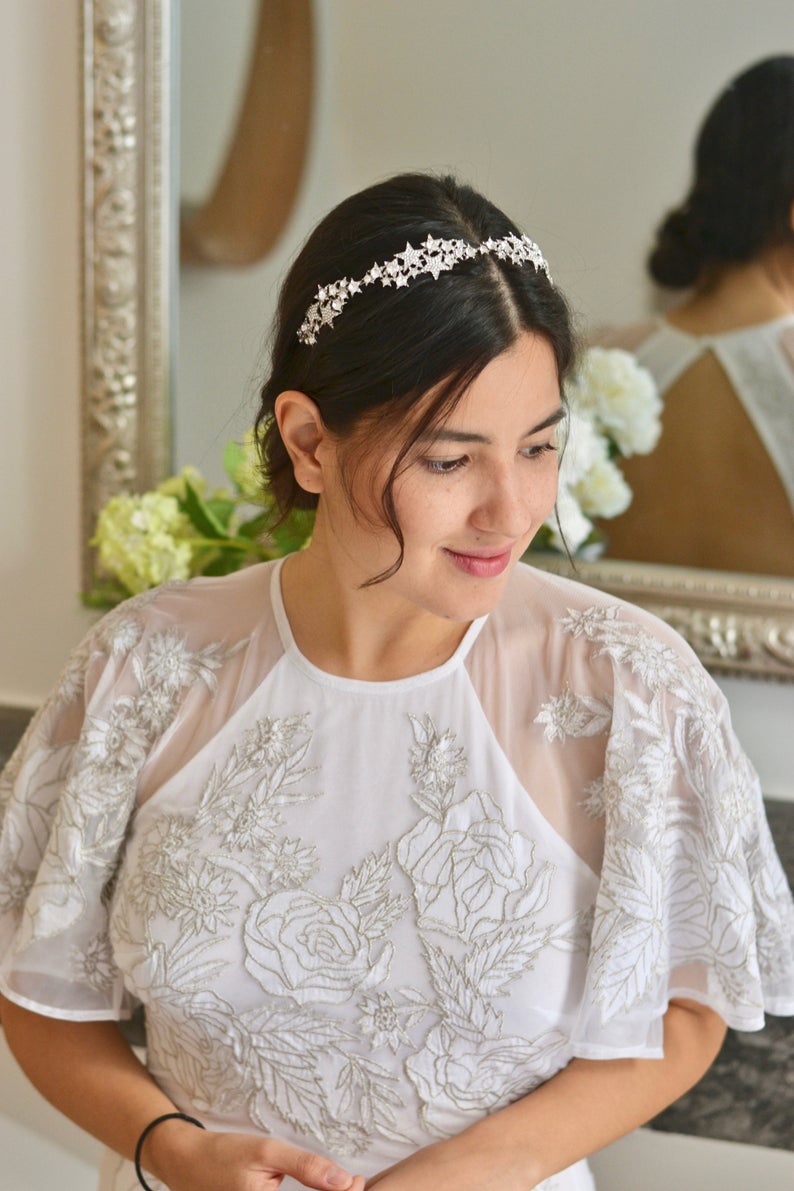 mariée prise en photo après ses préparatifs de mariage avec une coiffure en chignon et une headband étoiles