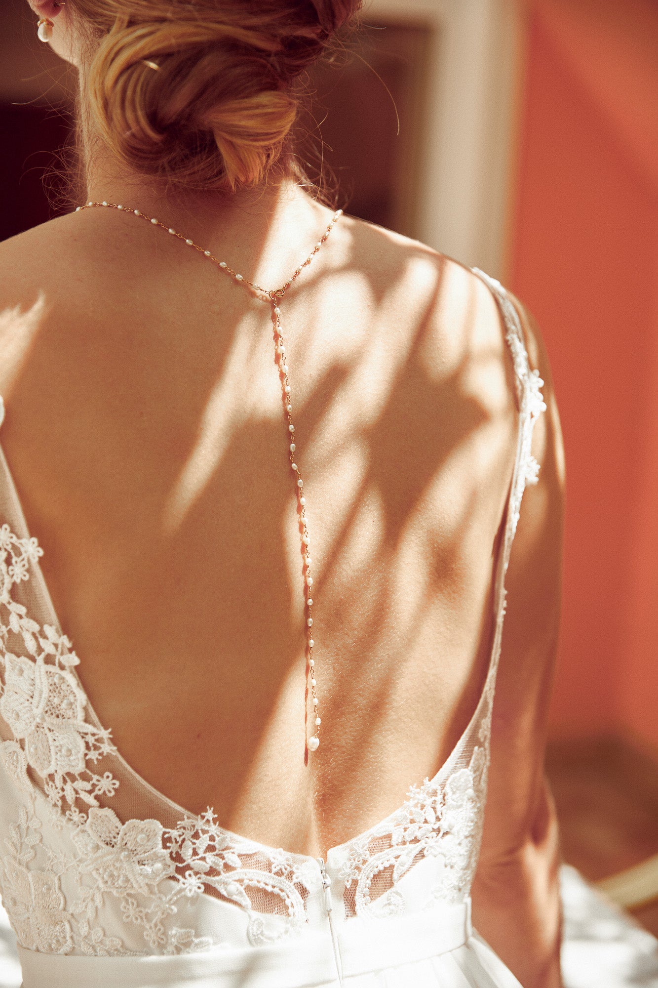 Collier decolleté de dos avec chaine perlée de culture