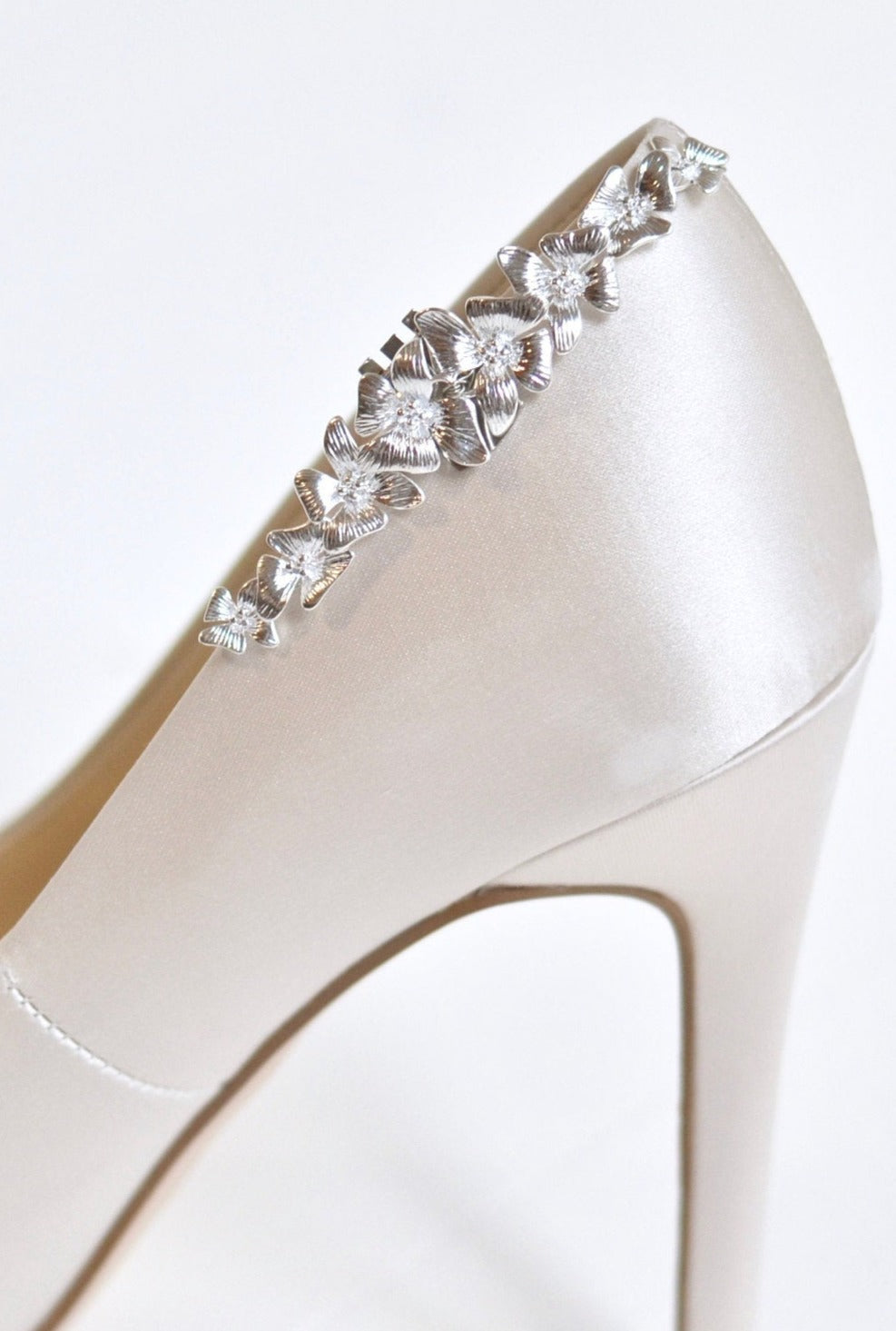 Clips à chaussures fleuris couleur argent sur des chaussures à talon beige