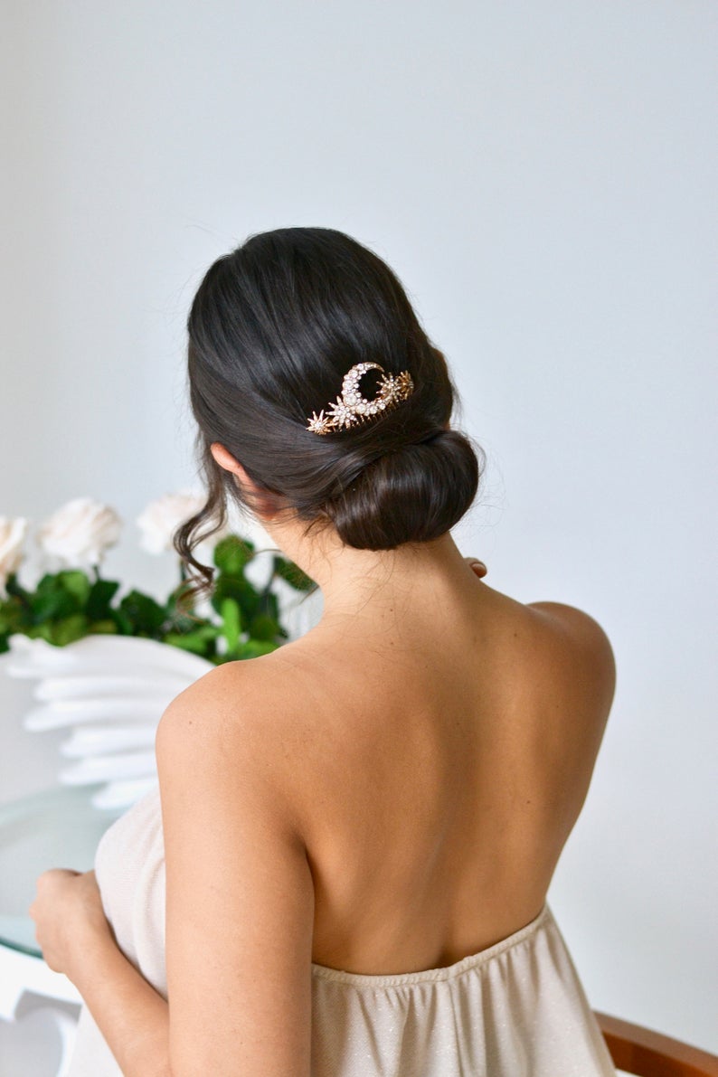 peigne céleste de mariage avec une lune et des étoiles sur un chignon bas