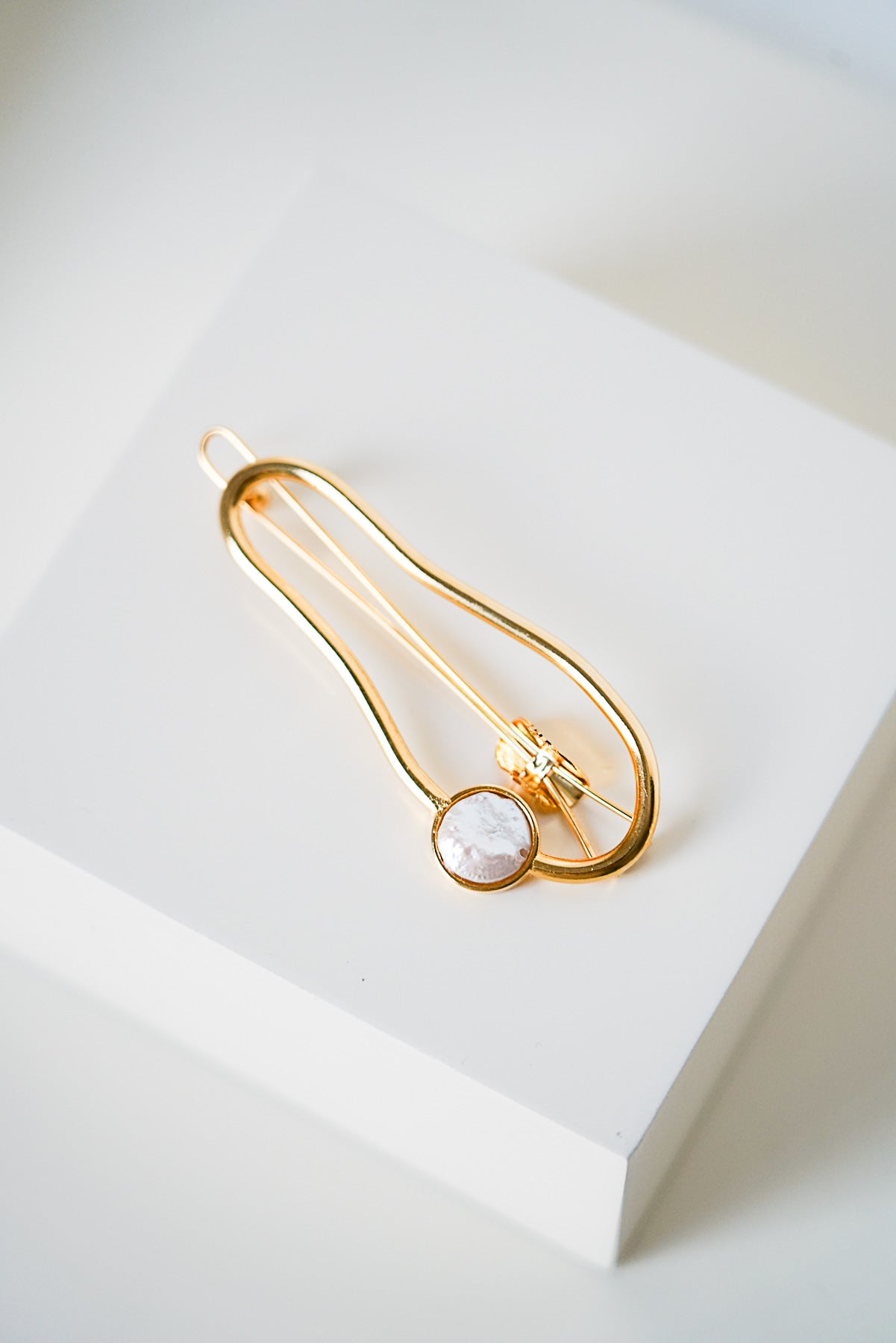 barrette minimaliste au style moderne en or avec un cristal brillant