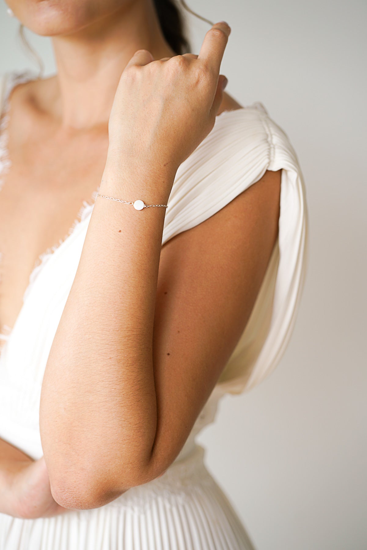 Mariée portant un bracelet argent avec un disque en perle mère simple