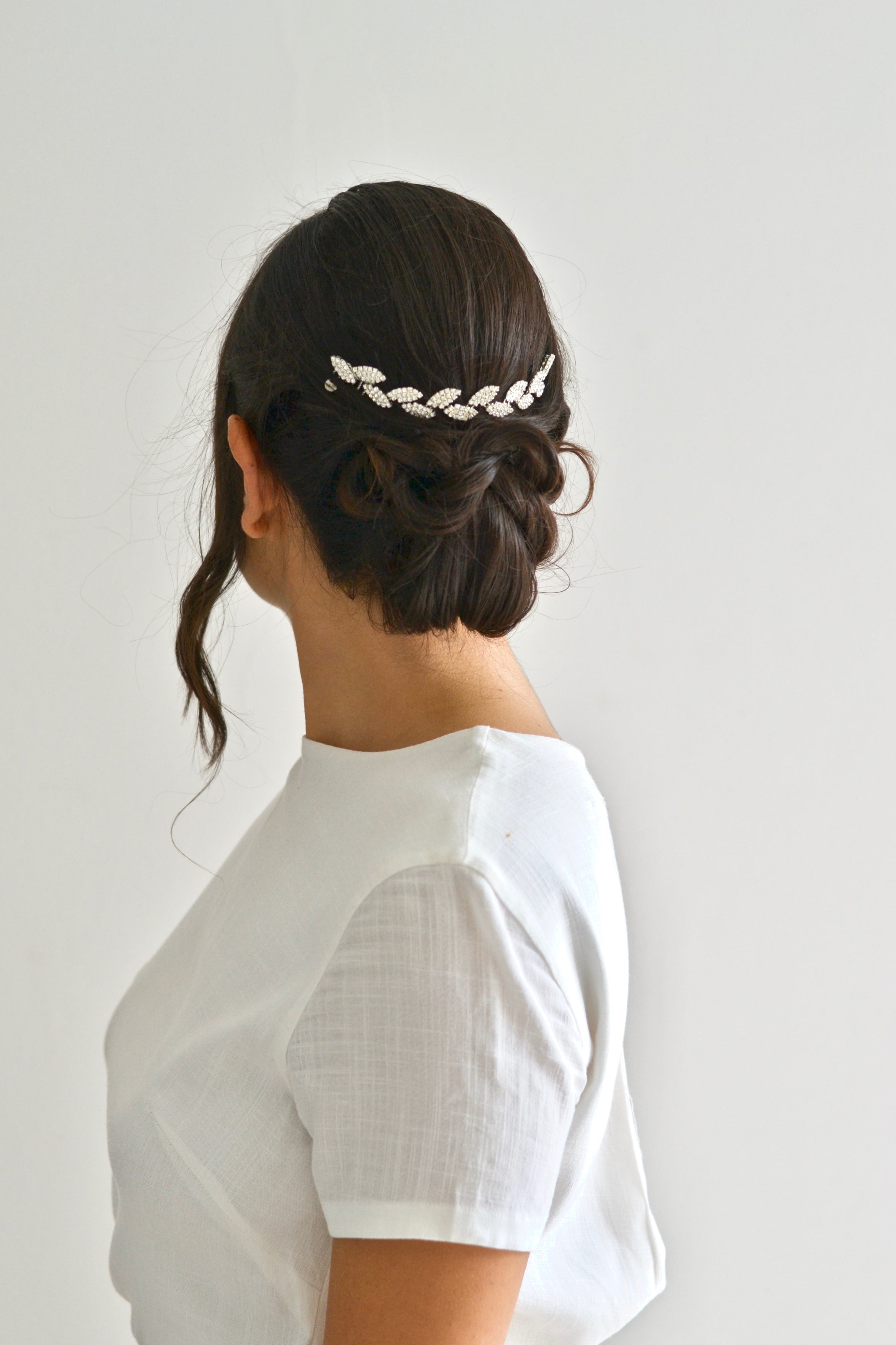 Mariée coiffure de mariage élégante portant une vigne de cheveux en feuilles argentées et cristaux