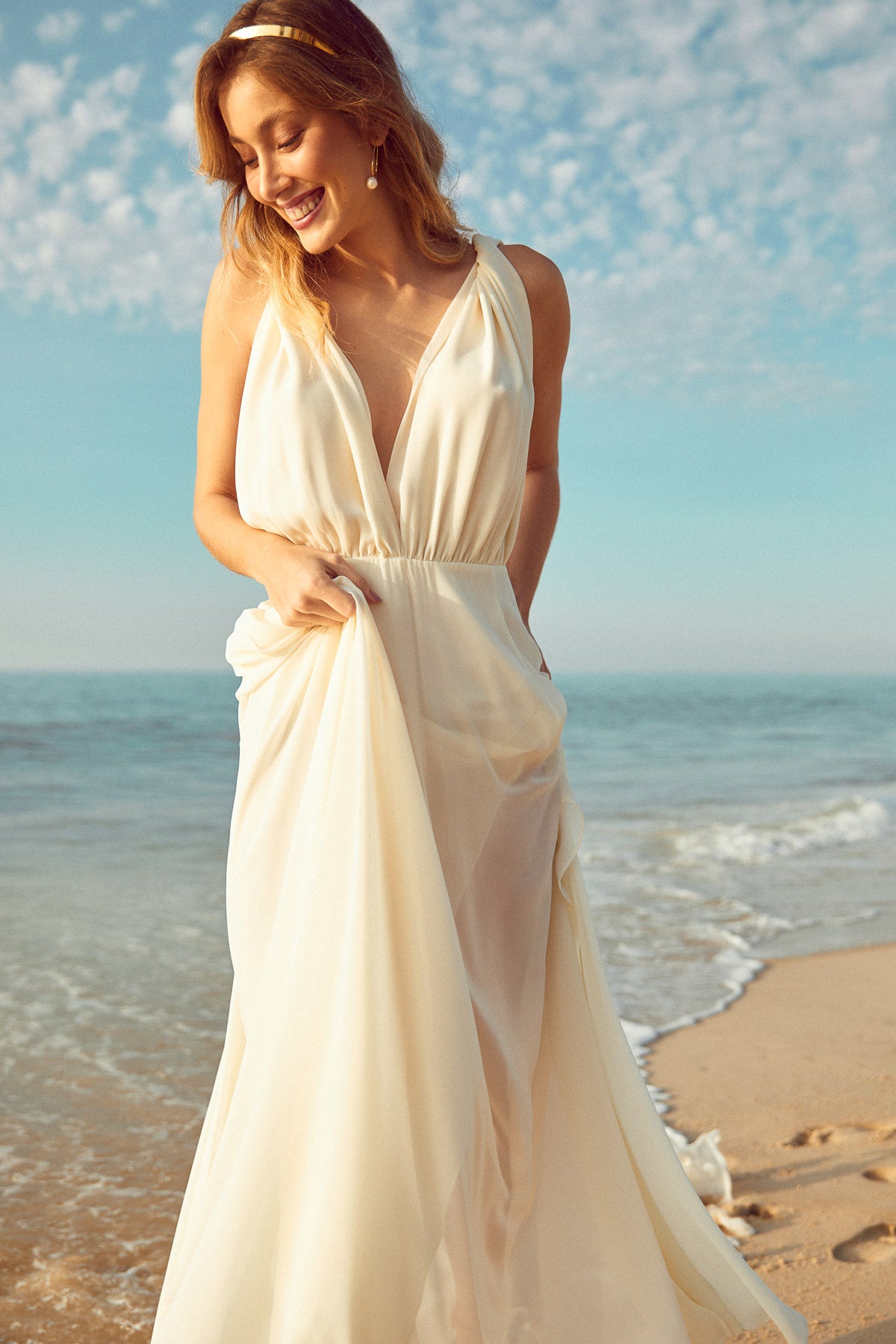 boucles d'oreilles mariage minimaliste en forme ovale avec une perle naturelle porté par une mariée à la plage