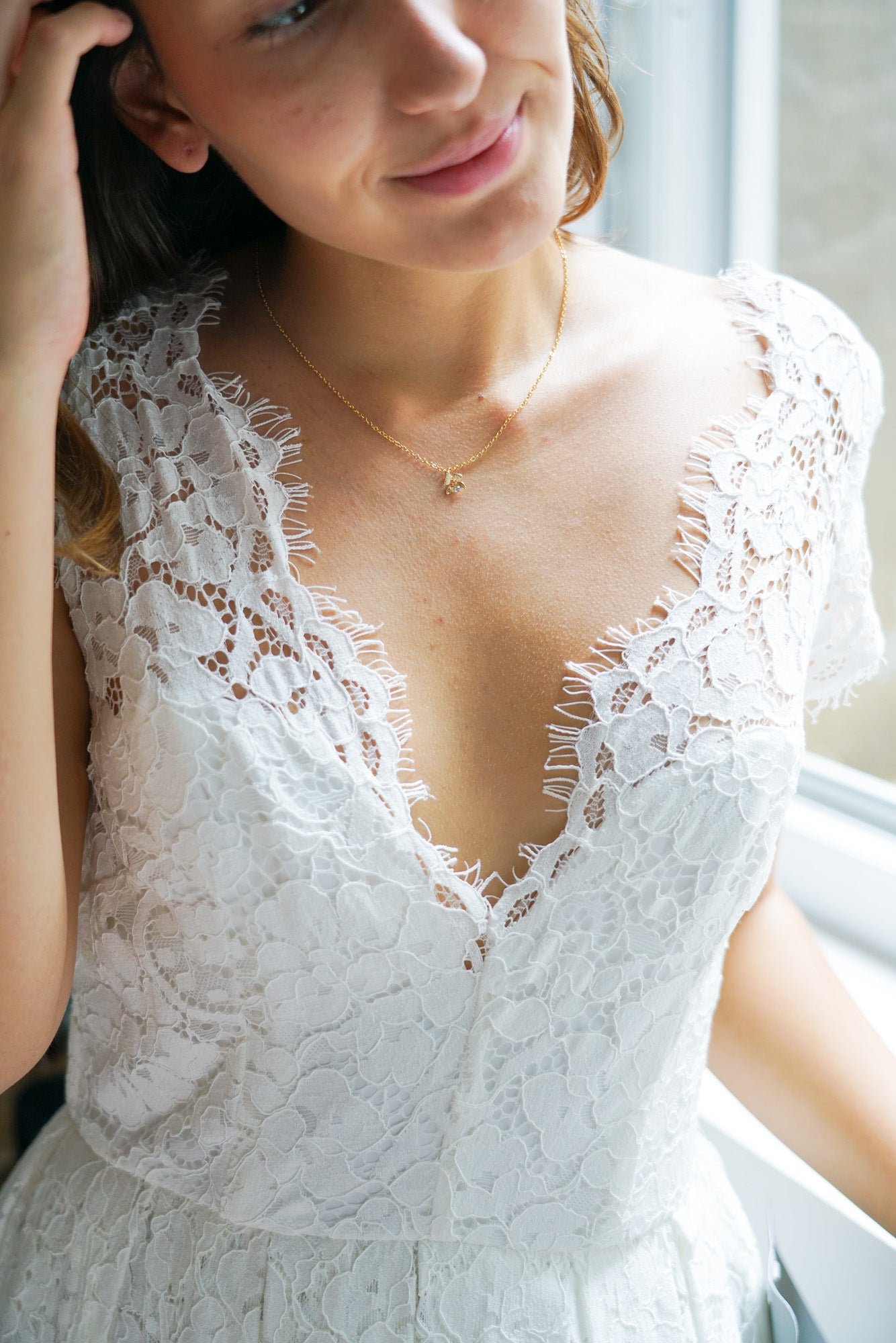 collier de mariage en or avec un pendentif porté par une mariée avec une robe de mariée