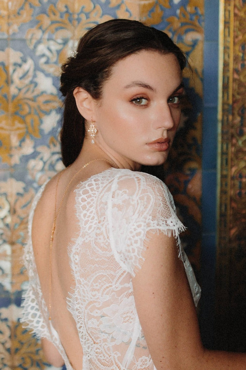 Mariée portant des boucles d'oreilles pendantes au style baroque