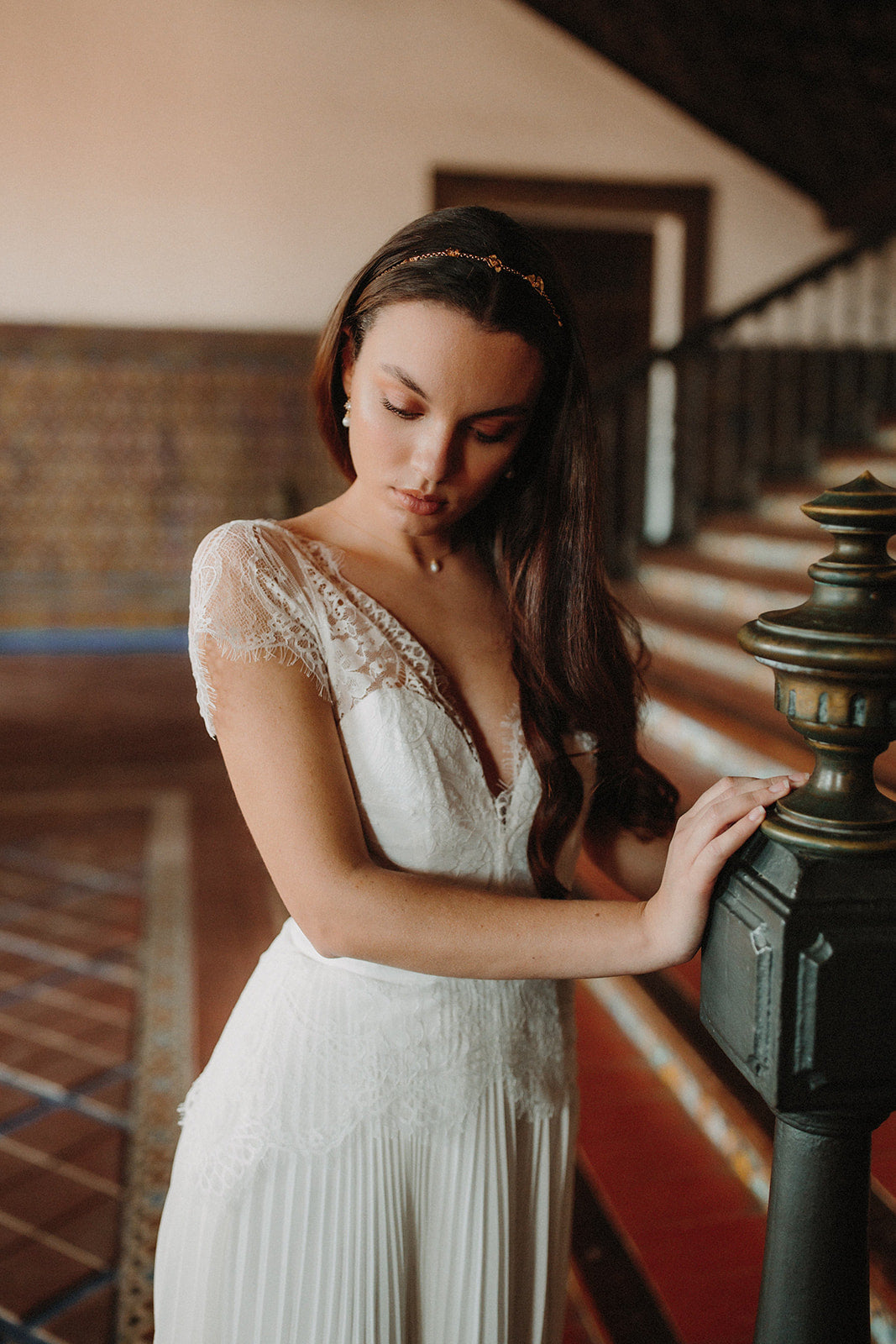Mariée en robe en dentelle bohème et coiffure avec une chaîne dorée à fleurs