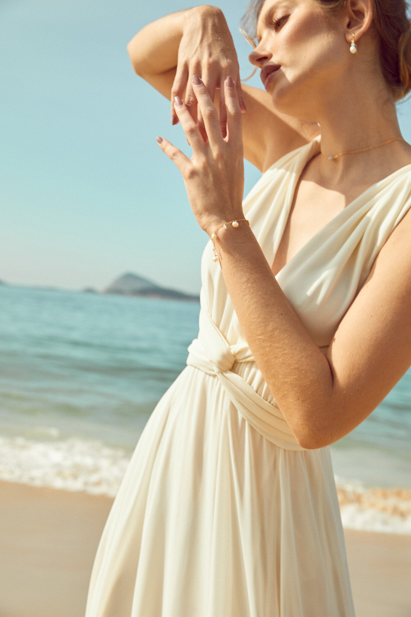 bracelet de mariage avec des perles naturelles blanches et des pierres naturelles bleu sur une mariée en robe blanche